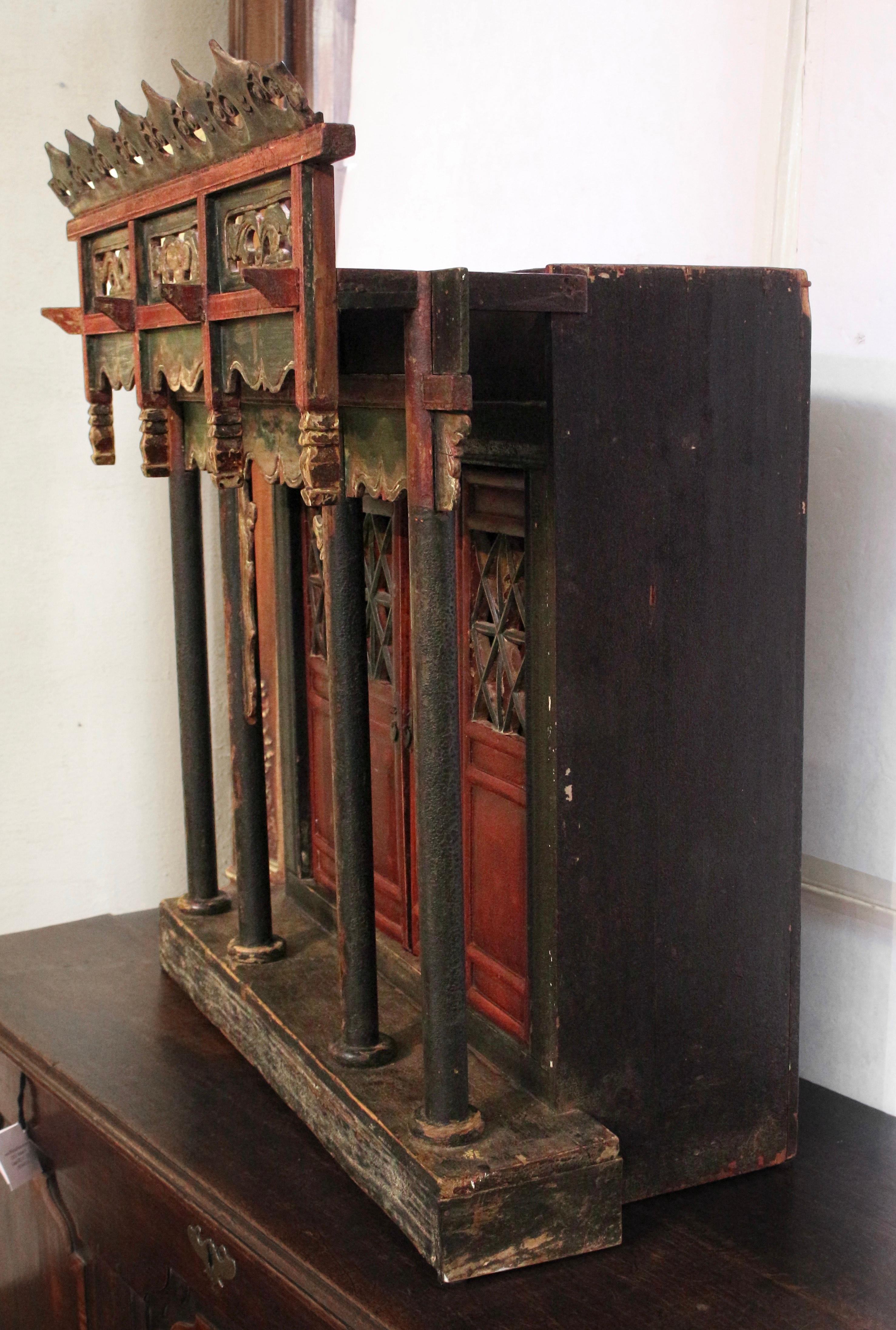 Late 19th century Chinese painted & gilt wood spirit house. Pagoda style Buddhist altar shrine. Flowing naturalistic motifs along the multi-dimensional colonnaded porch facade from the crown to cutwork panels & swag awnings. Latticework doors, the