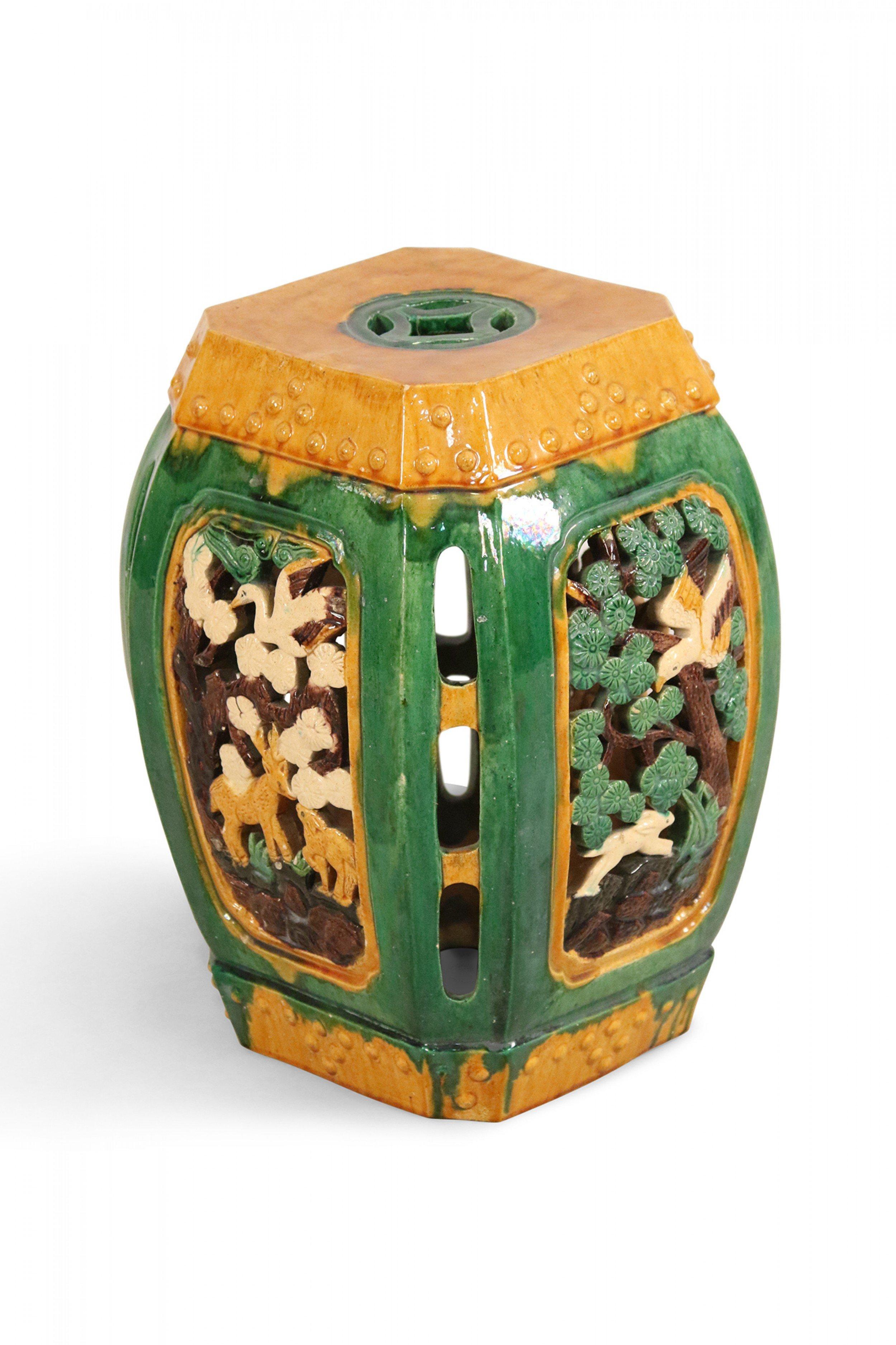 Chinese (19th-20th century) ceramic garden seat with filigree panels having a reticulated animal and floral design with a yellow and green glazed finish.