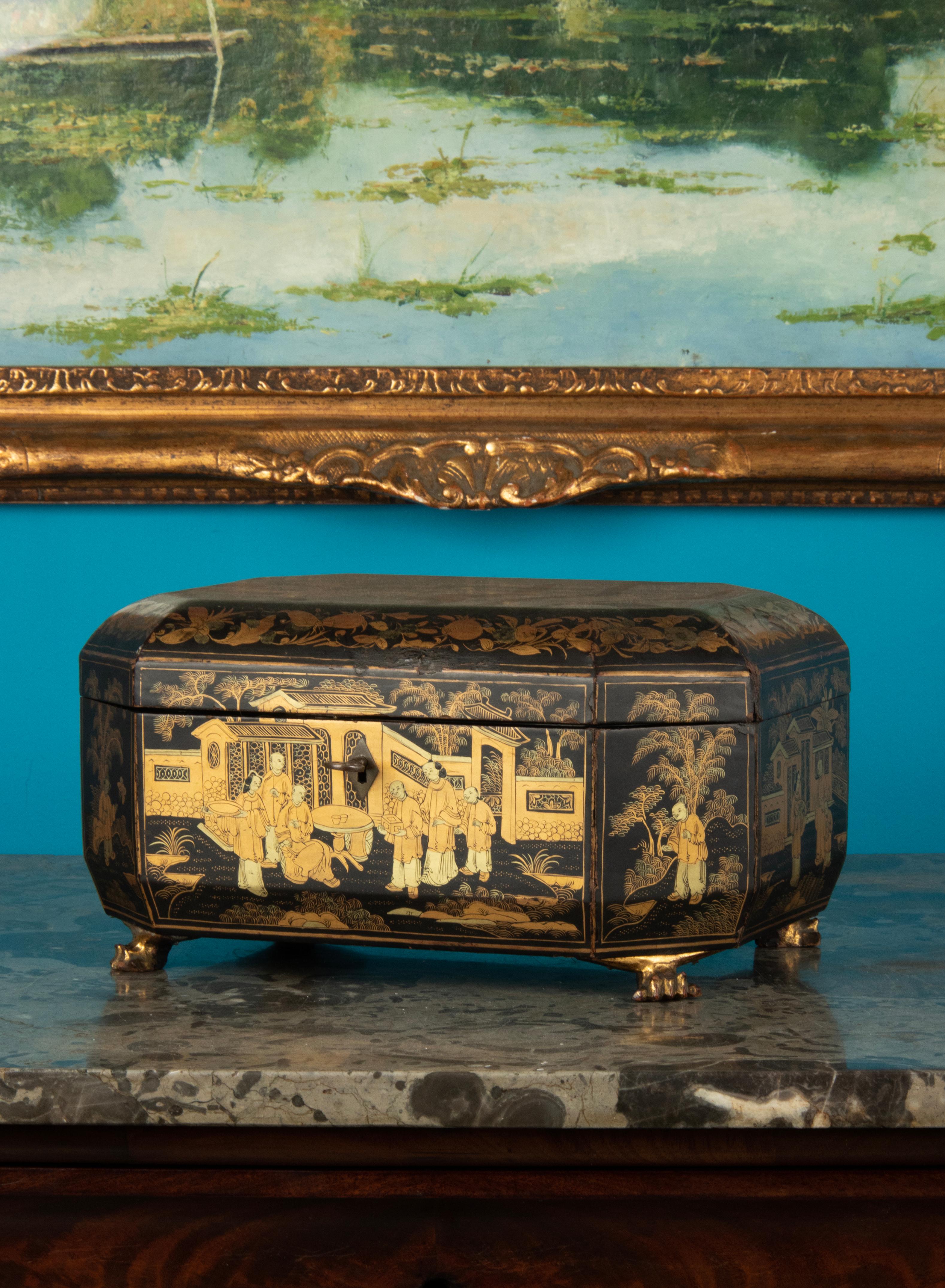 An antique hand-painted Chinoiserie lacquer tea caddy, with Chinese artistic influences. The interior is fitted with two covered and engraved lead canisters. It's made of lead to keep the tea free of moisture. The box is resting on wooden carved