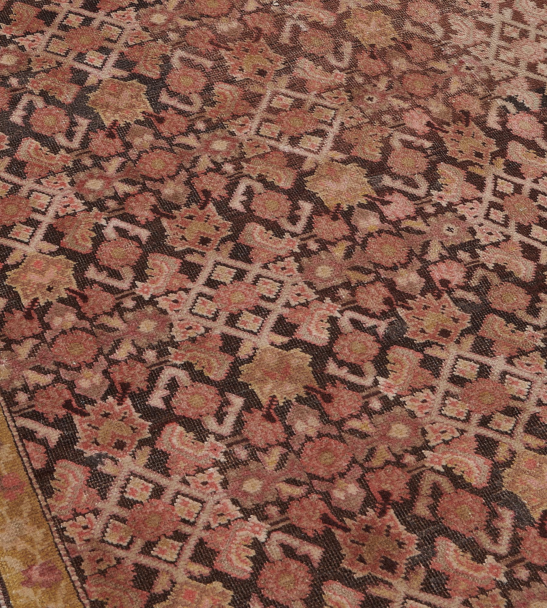 Ce chemin de table antique du Karabagh présente un champ brun chocolat avec un motif herati rouge brique et brun nuancé, dans une étroite bordure jaune tilleul de vigne à tête de fleur serpentant entre d'étroites rayures en forme de mât de barbier.