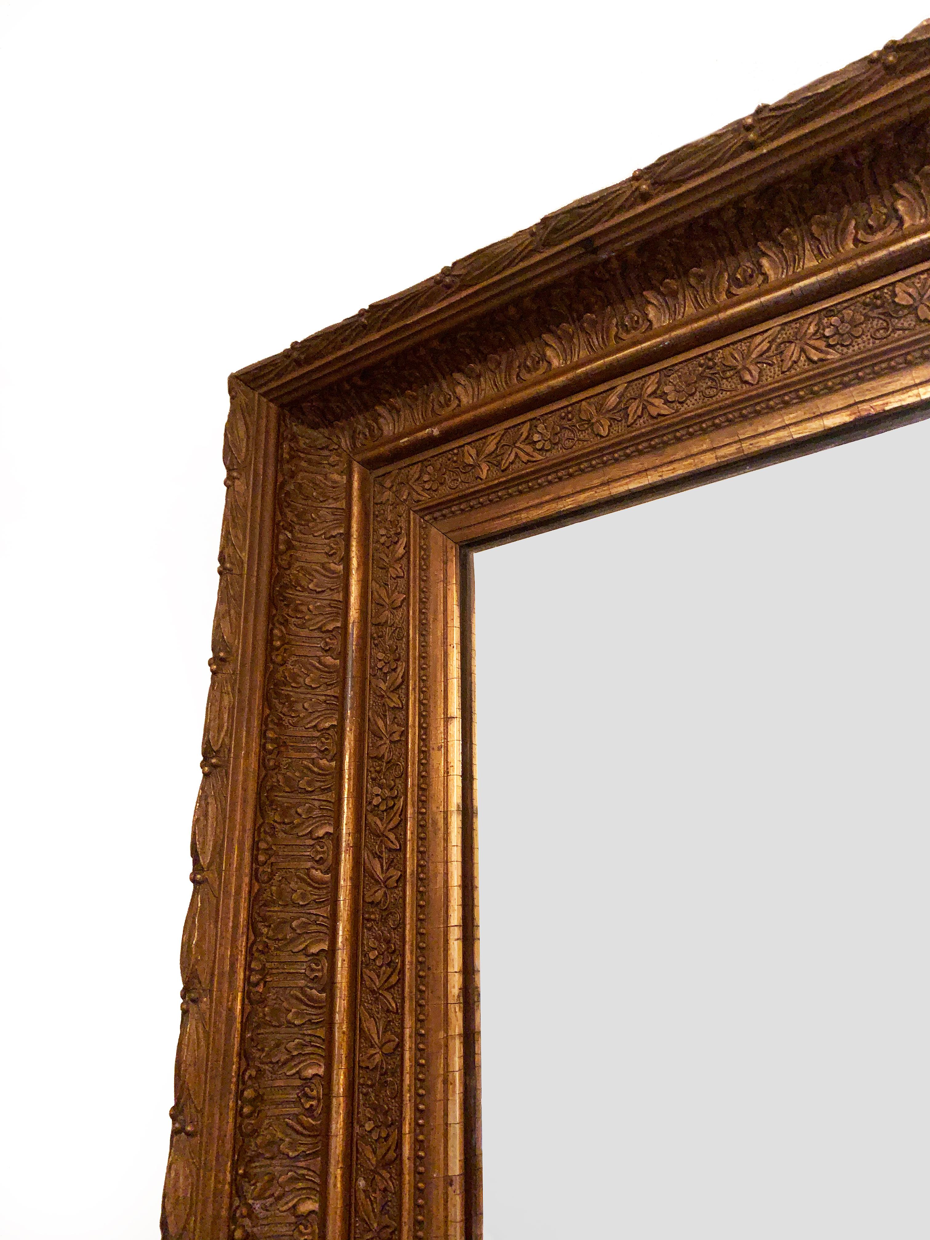 An imposing classical gilded rectangular mirror with a richly decorated cavetto frame. The deeply moulded frame exhibits laurel leaves, acanthus, and a daisy meander. The original mirror plate is retained in good condition.