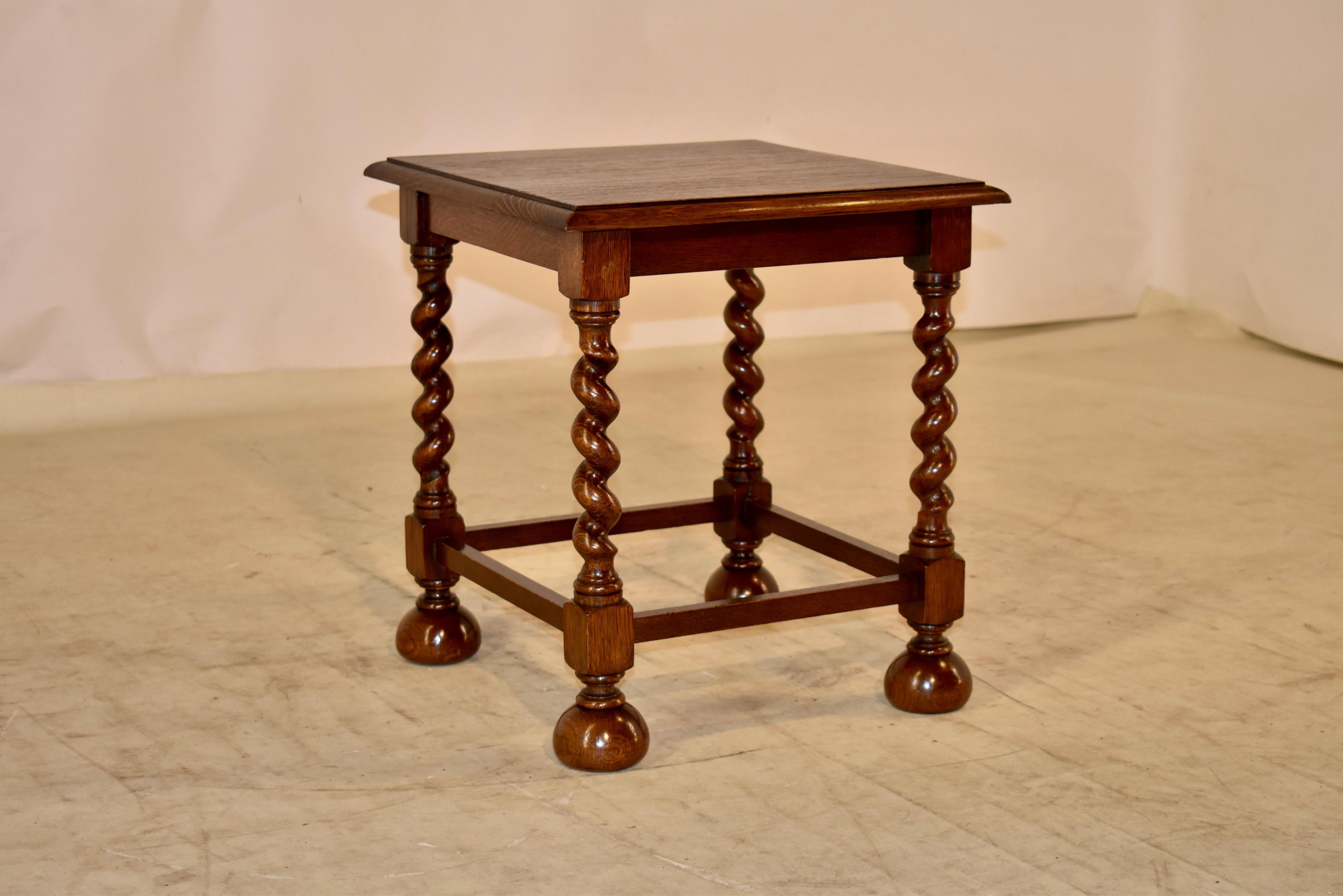 Late 19th century oak cocktail or end table from England. The top has a beveled edge, following down to a simple apron and wonderful and thickly hand turned barley twist legs. The legs have been joined by simple stretchers and are supported on large