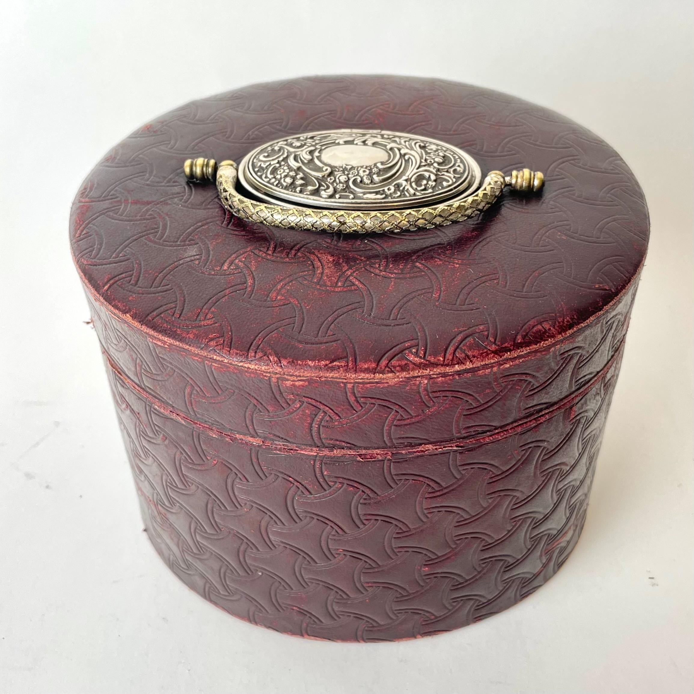 Boîte à colliers en cuir bourgogne avec une petite boîte à boutons de manchette en métal argenté sur le dessus, utilisée pour les cols détachables, 1890. Rangement supplémentaire sur le dessus, pour les boutons de manchette, les boutons de chemise
