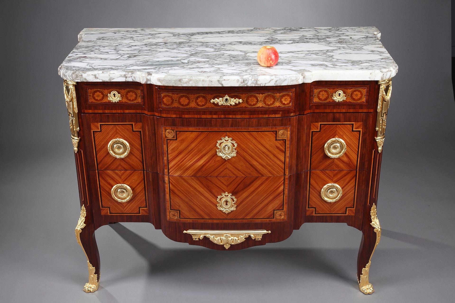 Late 19th century commode in Louis XV-Louis XVI style with 5 drawers, crafted of rosewood veneer and amaranth wood. This chest of drawers is topped by a Breche molded marble top. A marquetry motif of interlacing and flowers runs under the marble top