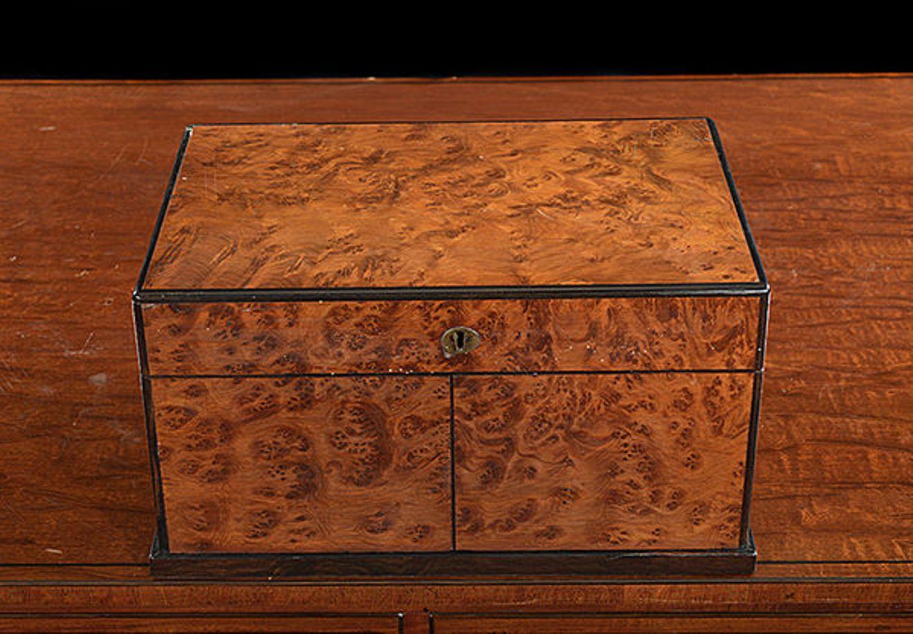 A Victorian burr yew wood and Coromandel box cabinet compendium of games which includes cribbage, chess, draughts and cards.
The rising lid with a folding chess board stored inside: the pair of fold back doors to the front store the chess pieces