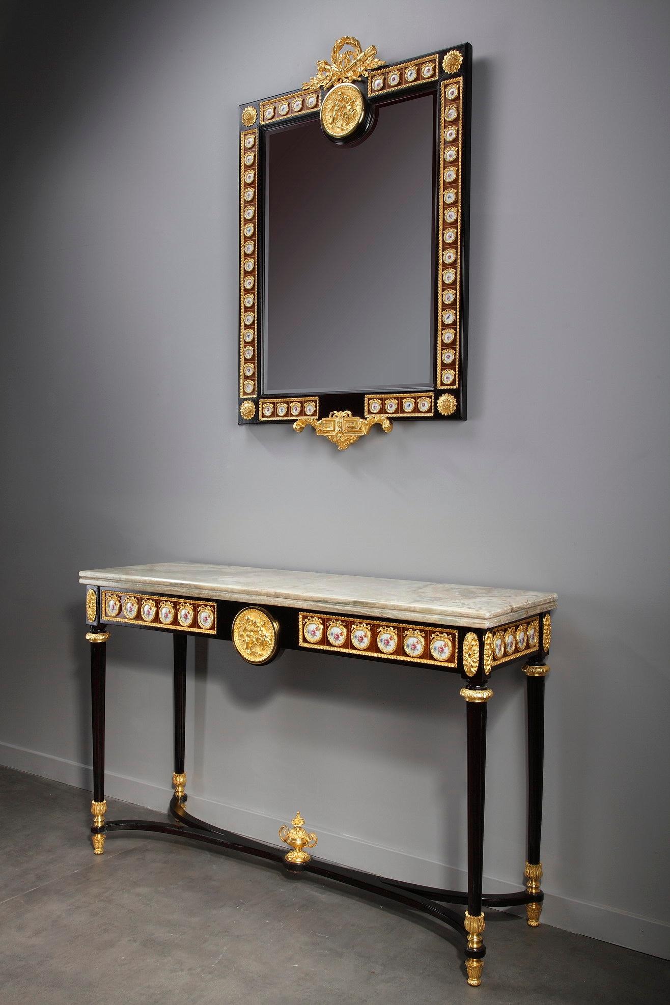Set of console table and mirror fashioned in the Louis XVI style. Crafted of natural mahogany stained wood, this exquisite set features porcelain and gilt bronze decoration.

The console rests on four straight fluted legs decorated with gilt bronze