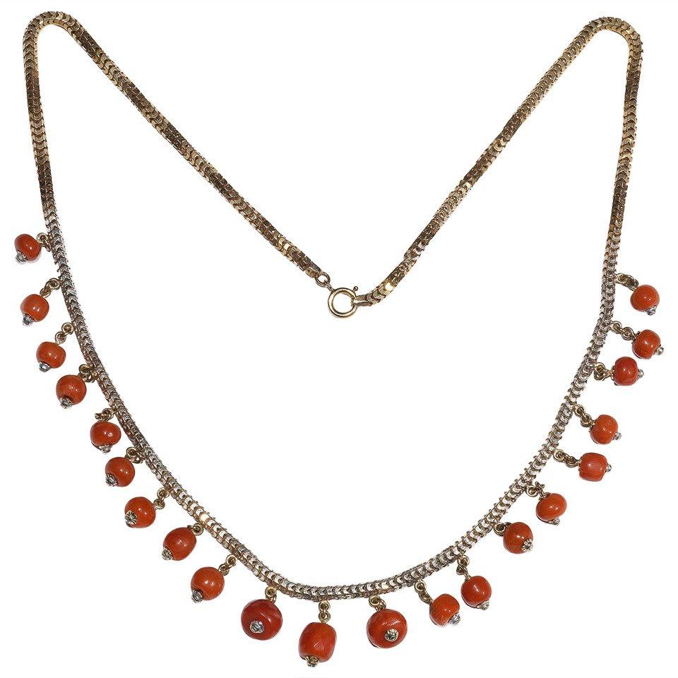 
A snake-link chain suspends a fringe of coral beads, length 40.5cm