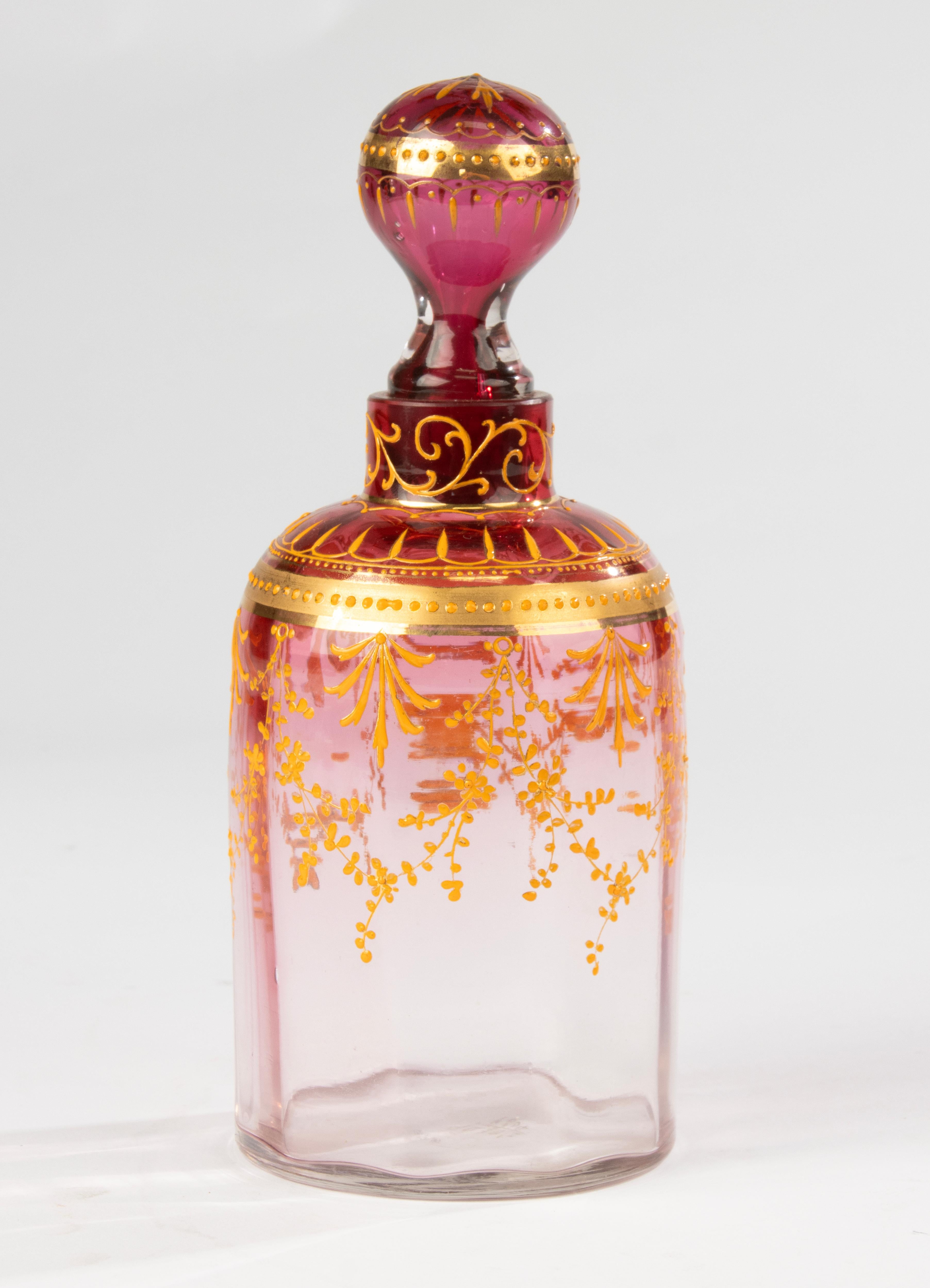 Elegant Bohemian glass decanter by Moser, dating to circa 1890. The piece features a deep ruby overlay with intricate gold enamel decoration in classic Moser style. Marked on the base, it stands 20.5 cm (8 in.) high with a diameter of 8 cm (3.15