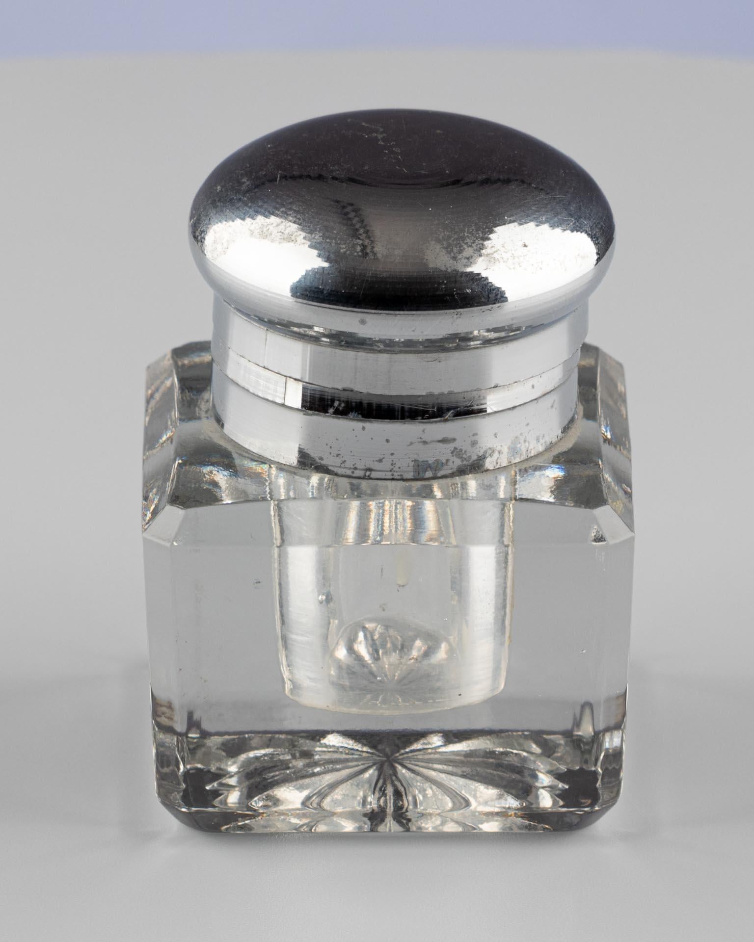 Cut Crystal Inkwell with Hinged Silver-Plated Lid

England or France
Cut crystal, silver-plated metal
Late 19th century

Dimensions:
H × W × D: 7 × 5 × 5 cm

Description:
A compact inkwell of clear, solid crystal with faceted sides and a finely cut