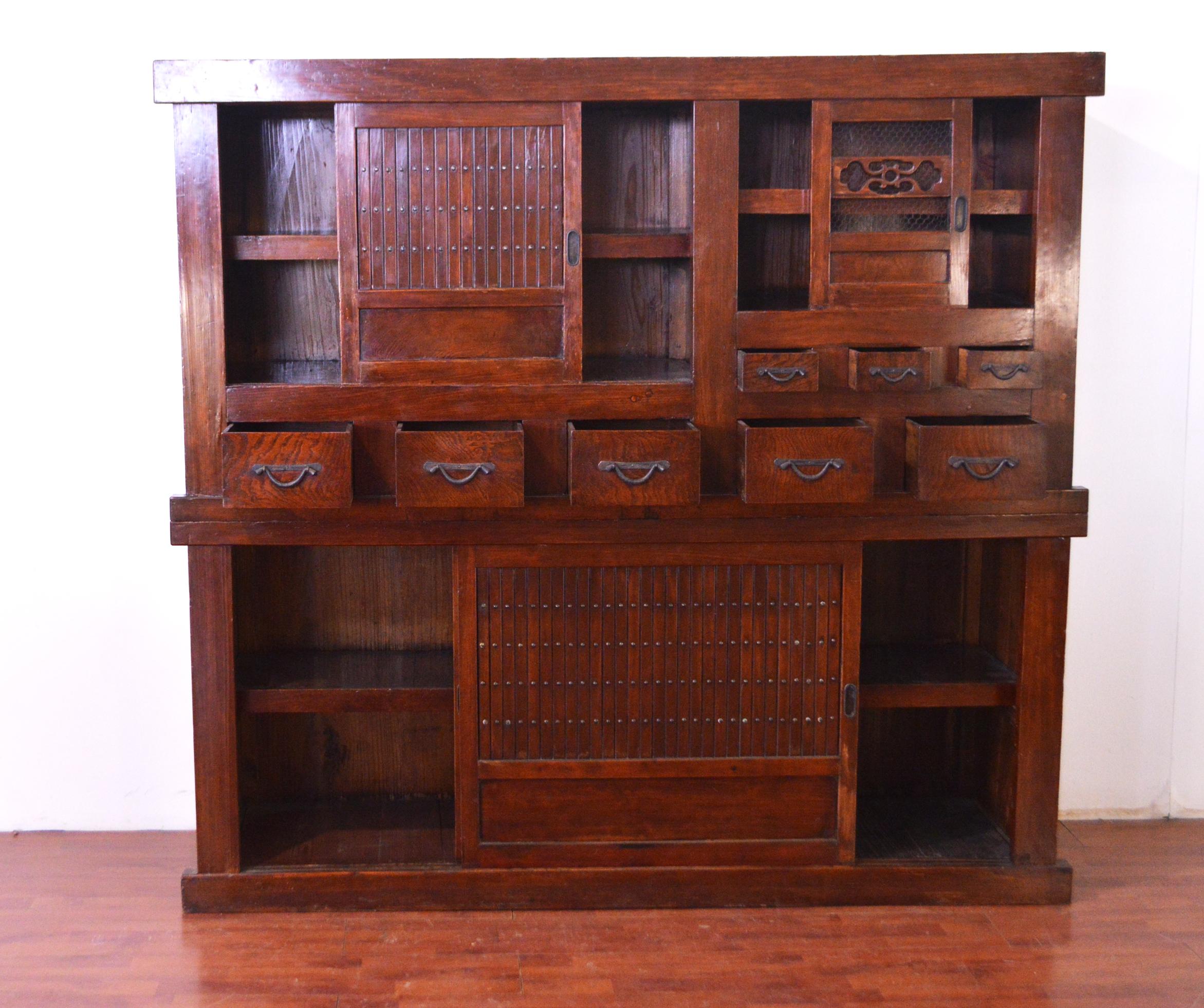 Elegant and with a Minimalist design late 19th century Japanese kitchen chest, typically called Mizuya Dansu. It is the most common term for two-section stacking kitchen chest. The lower part has two big sliding doors decorated with studs, while the