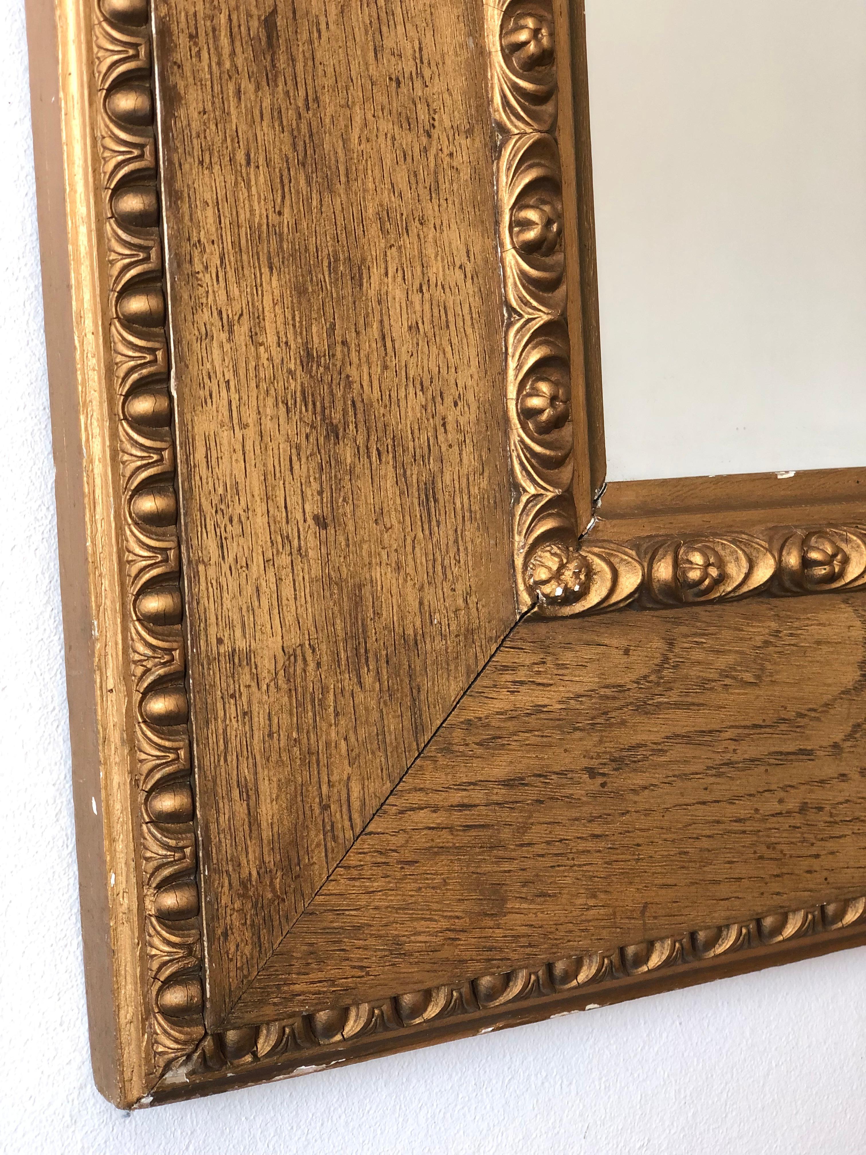 An authentic late 19th century Danish giltwood mirror, crafted by the renowned court gilder W. J. Mogensen in Copenhagen. The frame reflects a refined Biedermeier influence, with a broad wood-grained surface and a richly detailed gilt border