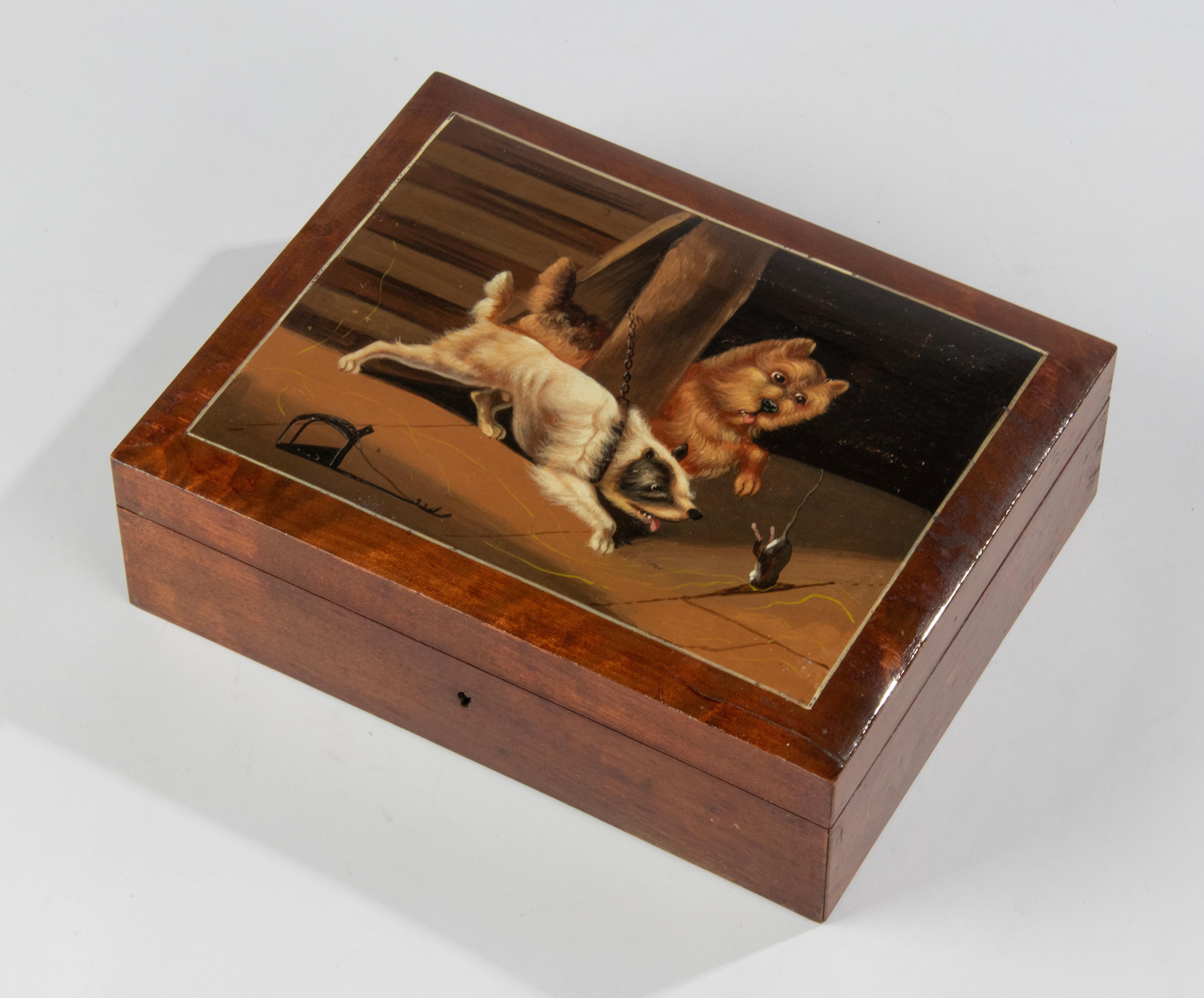 A beautiful antique wooden box. The lid is hand painted with a cheerful representation of two playing dogs who try to catch a mouse. 
The painting is bright in color and refined. It is not signed.
The box is in good and original condition, only
