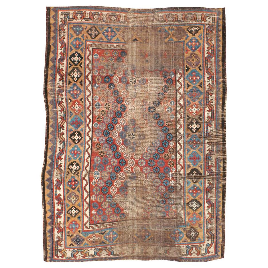 A distressed antique Persian Kurd carpet from the late 19th century.

Measures: 4' 6