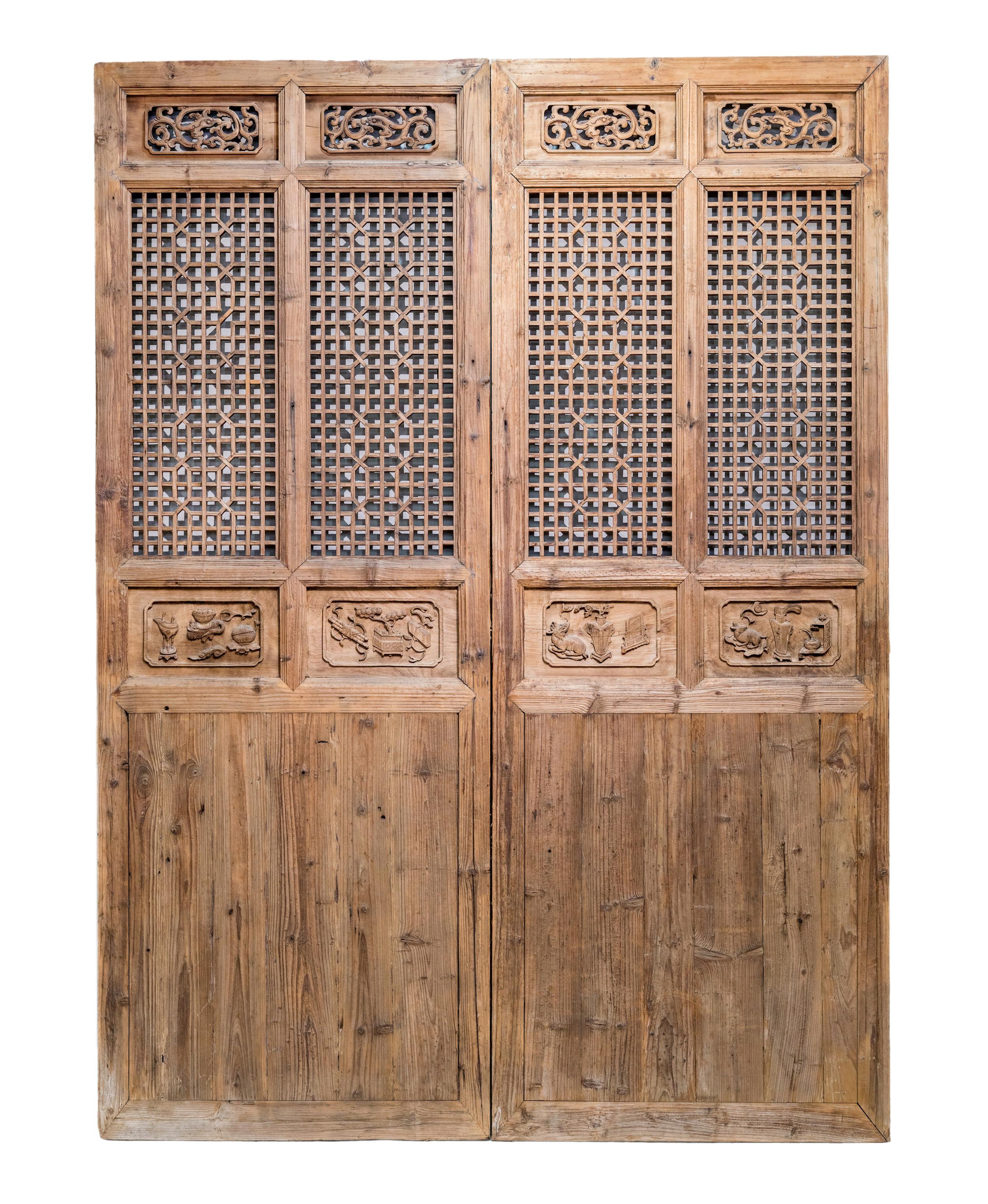 Late 19th century double-width door panels from Zhejiang province, China. The framework and plain bottom panels are made of fir wood, while the latticework portion is made of Elm wood. The middle carvings are made of Camphor wood, and have very deep