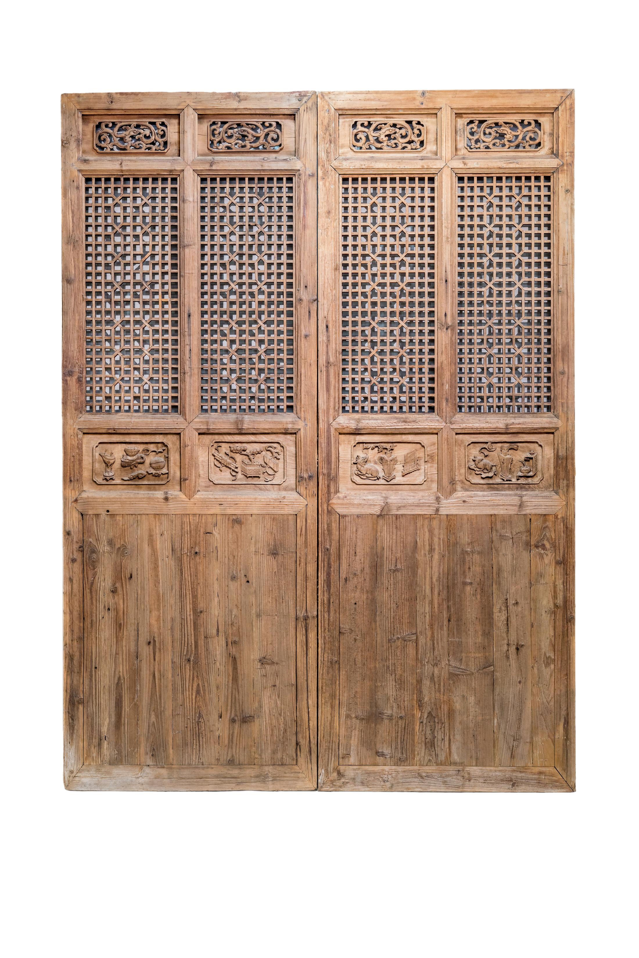 Late 19th century double-width door panels from Zhejiang province, China. The framework and plain bottom panels are made of Fir wood, while the latticework portion is made of Elm wood. 
Overall these doors have a simple design but the highlight is