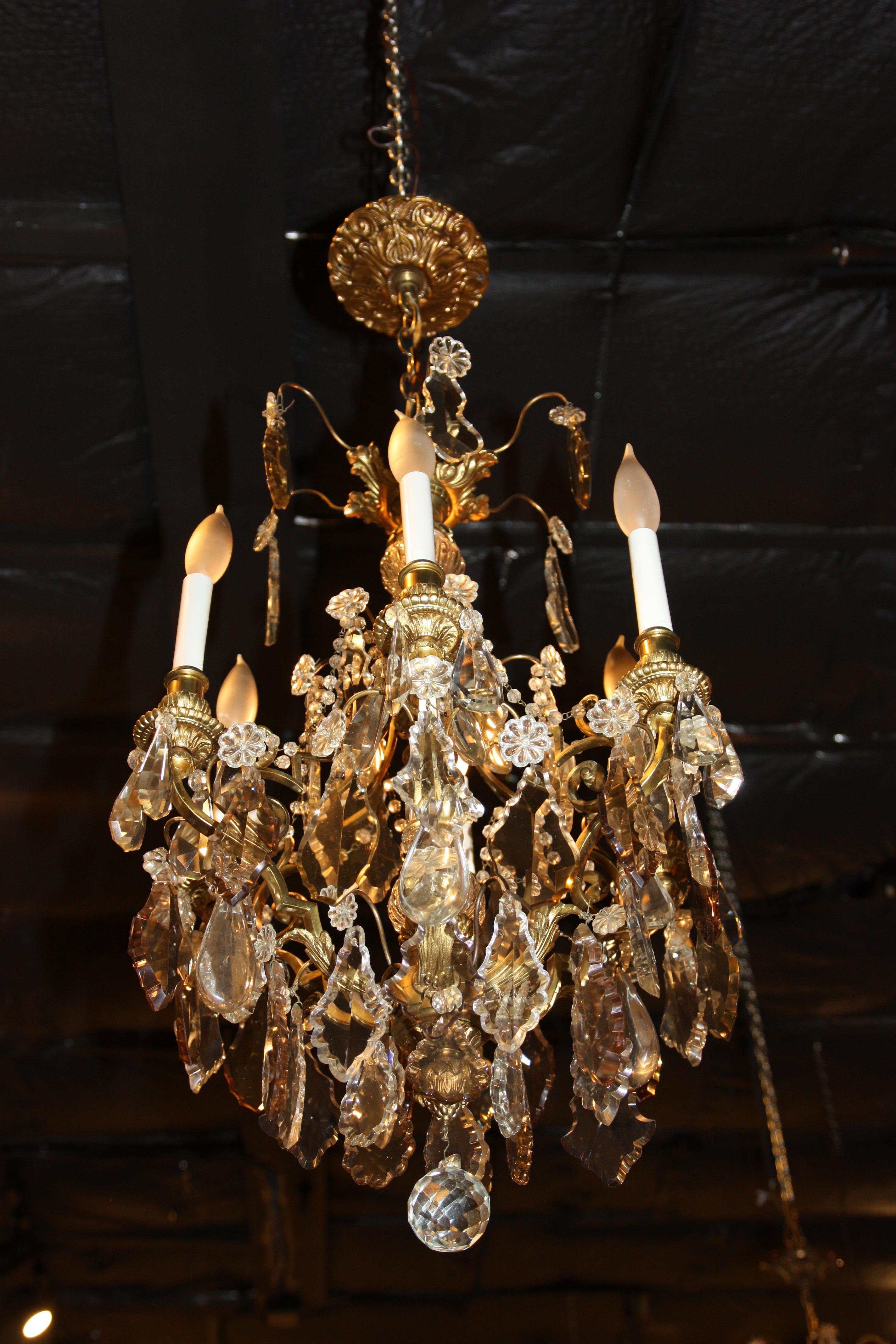 An exceptional dore bronze chandelier with faceted crystal prisms seven candles.