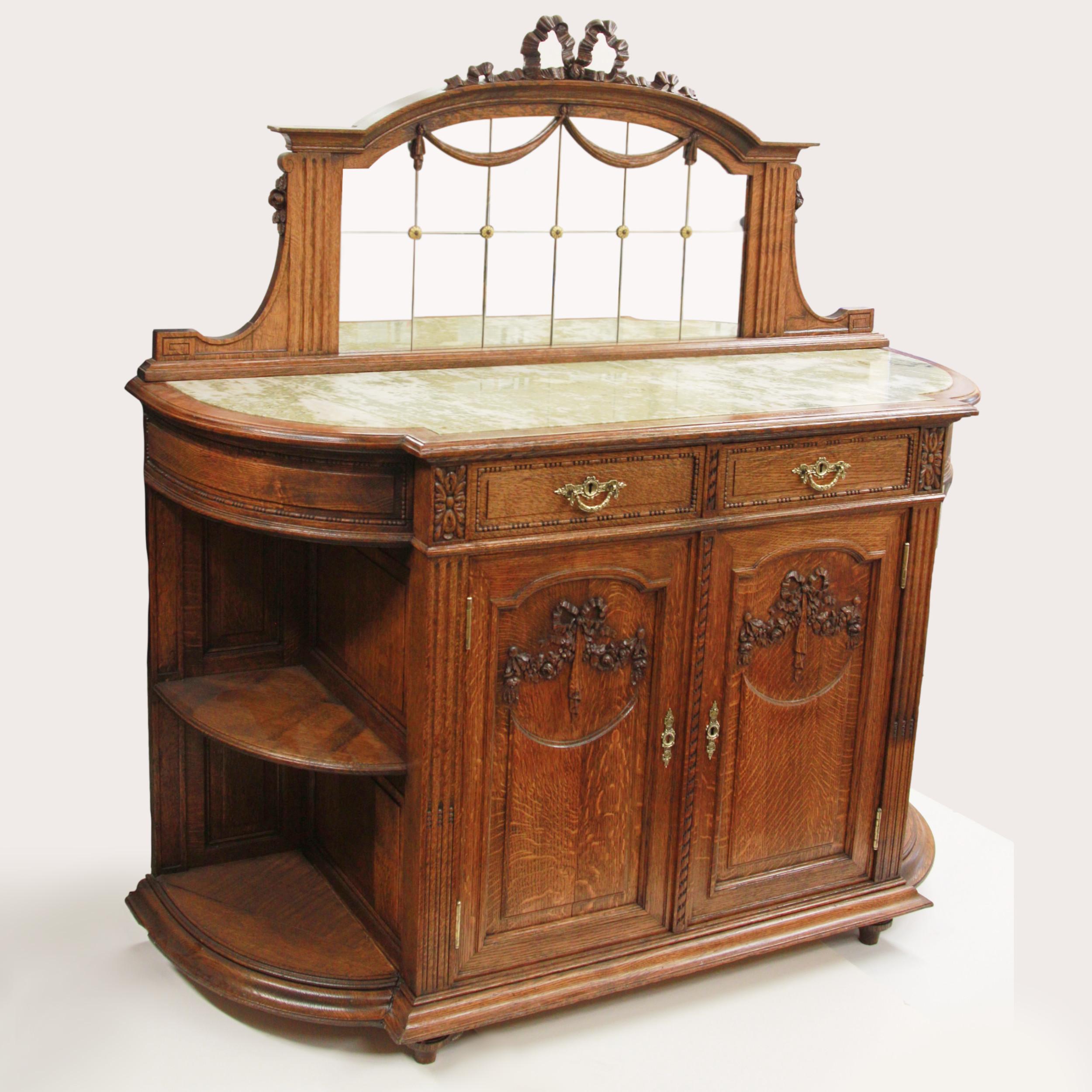 Stunning turn-of-the-century Dutch Buffet

Features include:

- Solid flamed oak construction
- High-relief carving throughout
- Green & white inset marble top
- (2) Drawers
- (2) Doors
- (1) Interior shelf
- (4) external shelves
- Solid brass