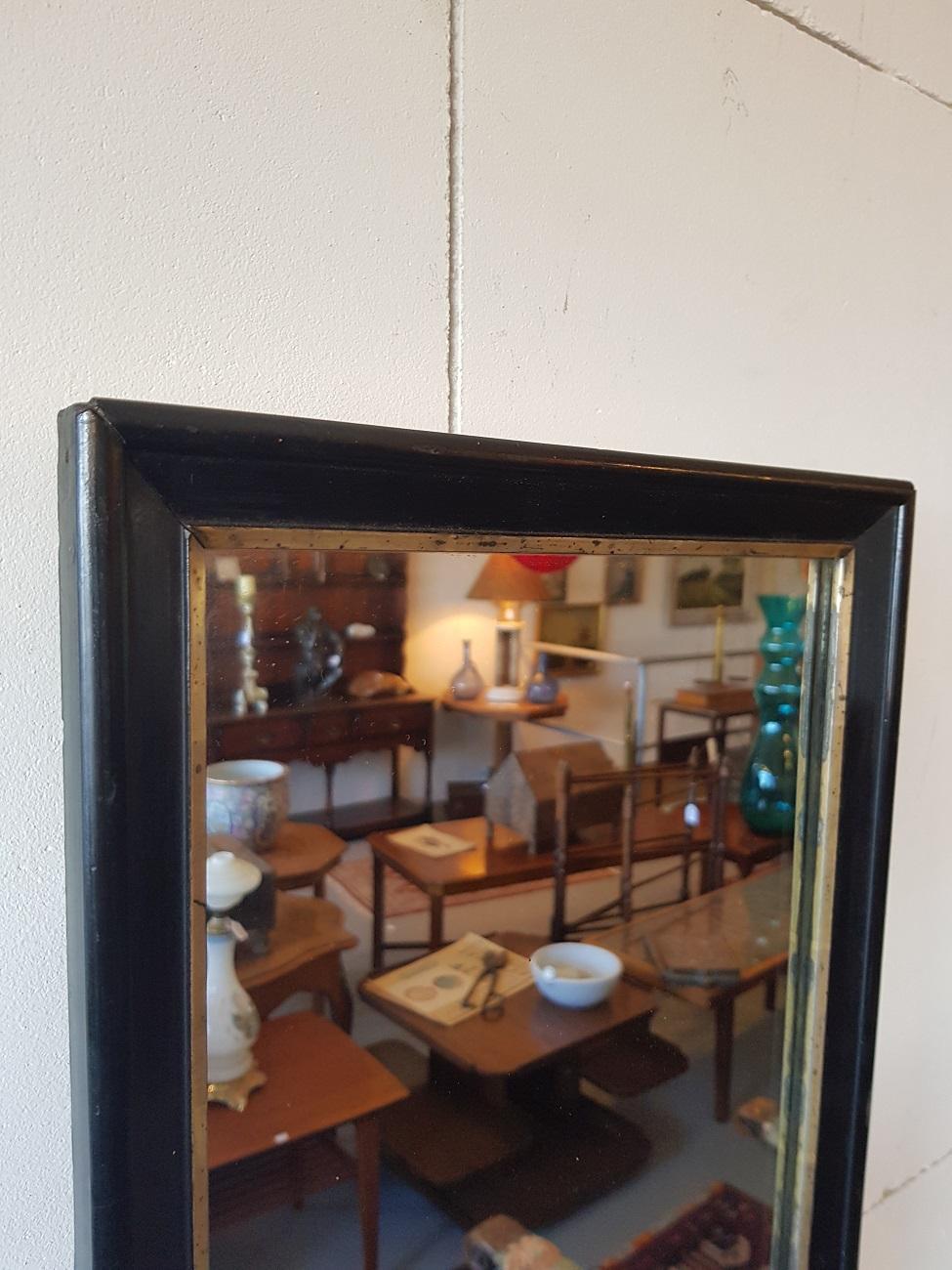 Beautiful antique Dutch mirror with a black lacquered wooden frame and a gold / silver striping, late 19th century.

The measurements are:
Depth 2.5 cm/ 0.9 inch.
Width 32 cm/ 12.5 inch.
Height 67 cm/ 26.3 inch.