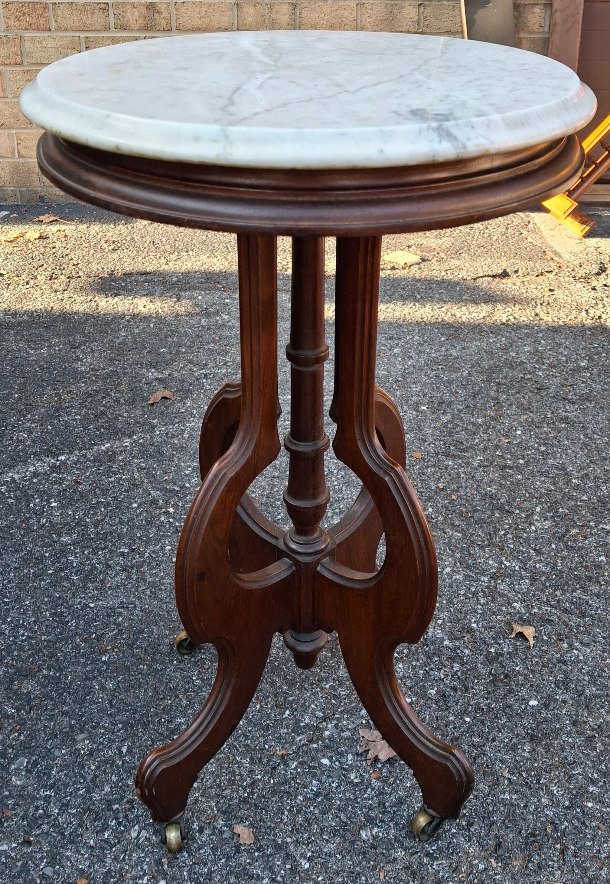 A Late 19th Century Eastlake Style Walnut and Marble Tip Oval Rolling Side Table. 
Dimensions:  23