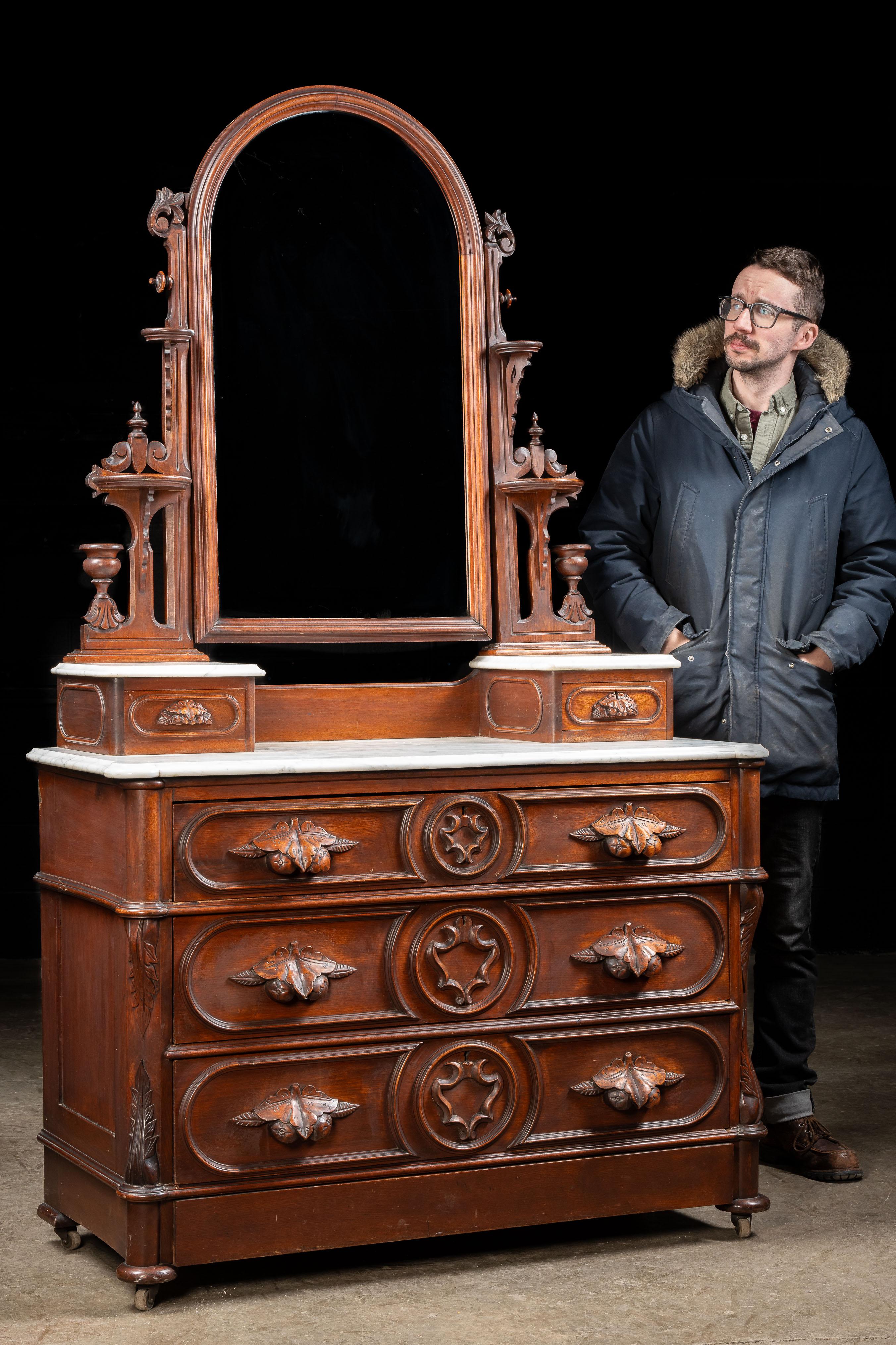 Ancienne commode victorienne et miroir.

Fabriquée en noyer, cette commode renvoie à l'époque de l'artisanat américain de qualité supérieure. Le plateau de marbre incurvé est doté de deux boîtes à bijoux ou boîtes fourre-tout, d'un rangement optimal