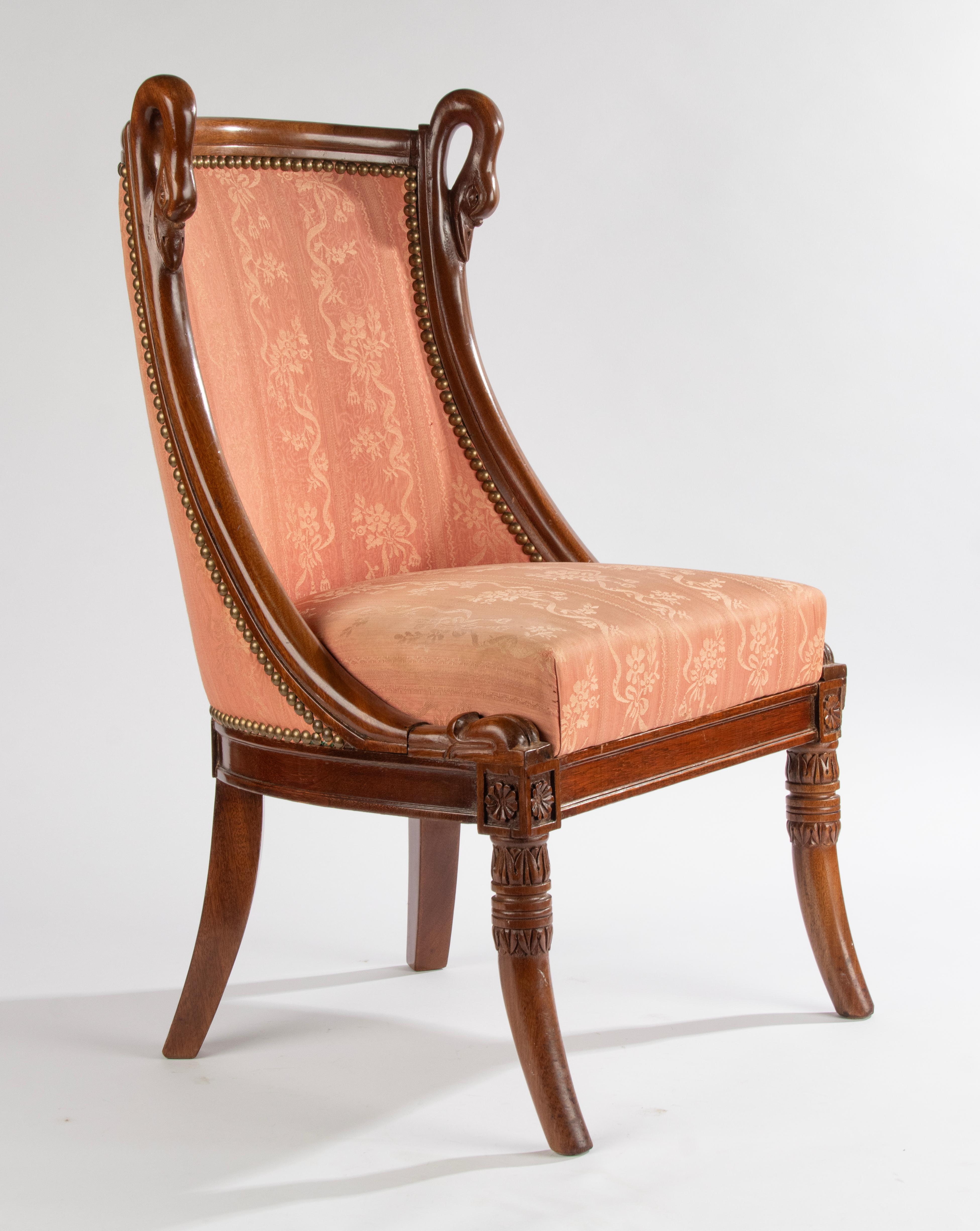 An elegant and rare childrens 'Bergère chair made in Empire style. Made of finely carved beechwood. At the top swan heads, which is a typical ornate of the Empire style. Upholstered with silk fabric. Made in France around 1880-1890. It also can be