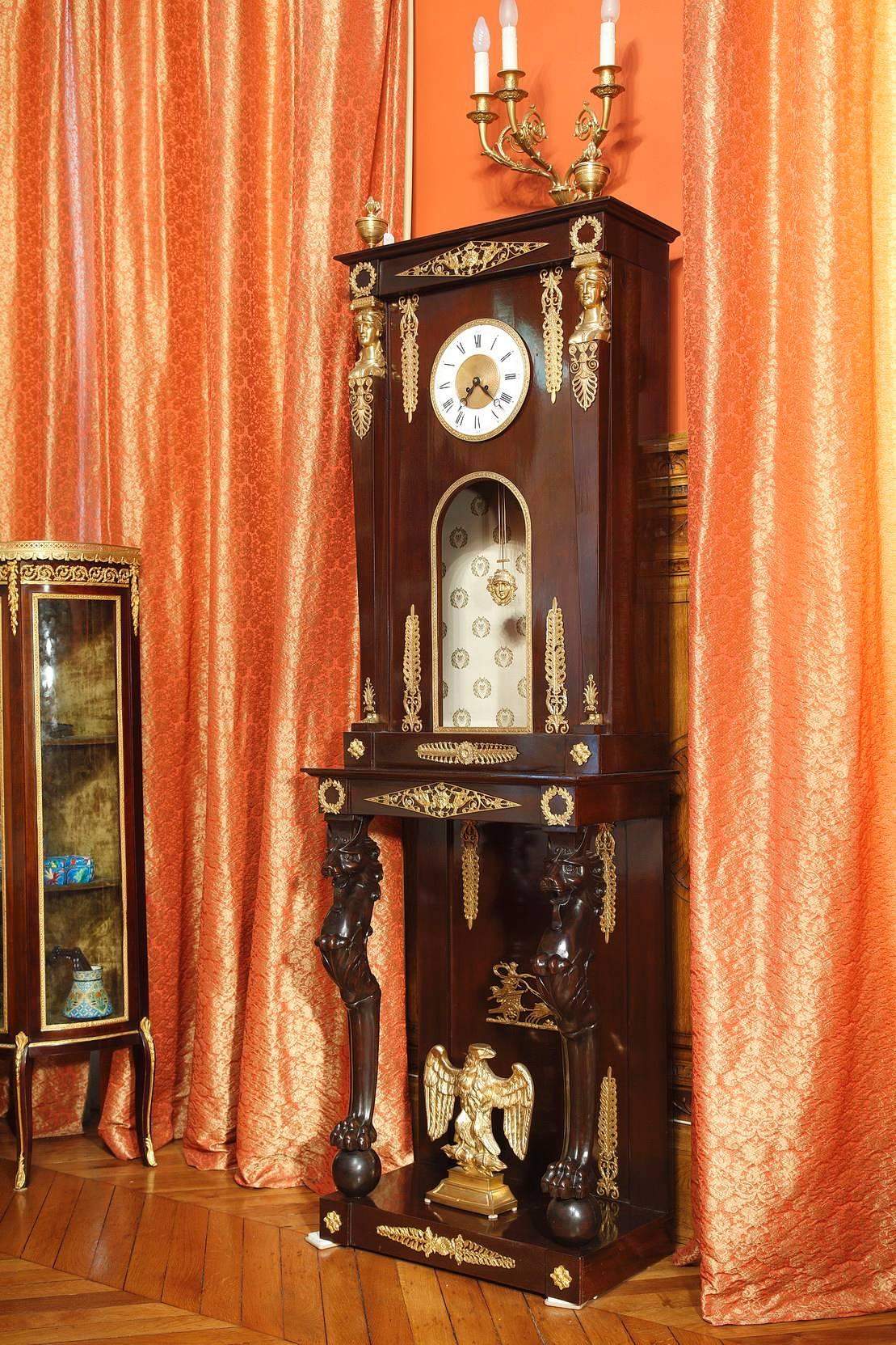 Impressive mahogany longcase clock with gilt and sculpted decorative bronze elements such as fantastic animals, diamond-shaped patterns, scrollwork, and foliage. This floor clock is composed of two parts: the upper part which contains the white