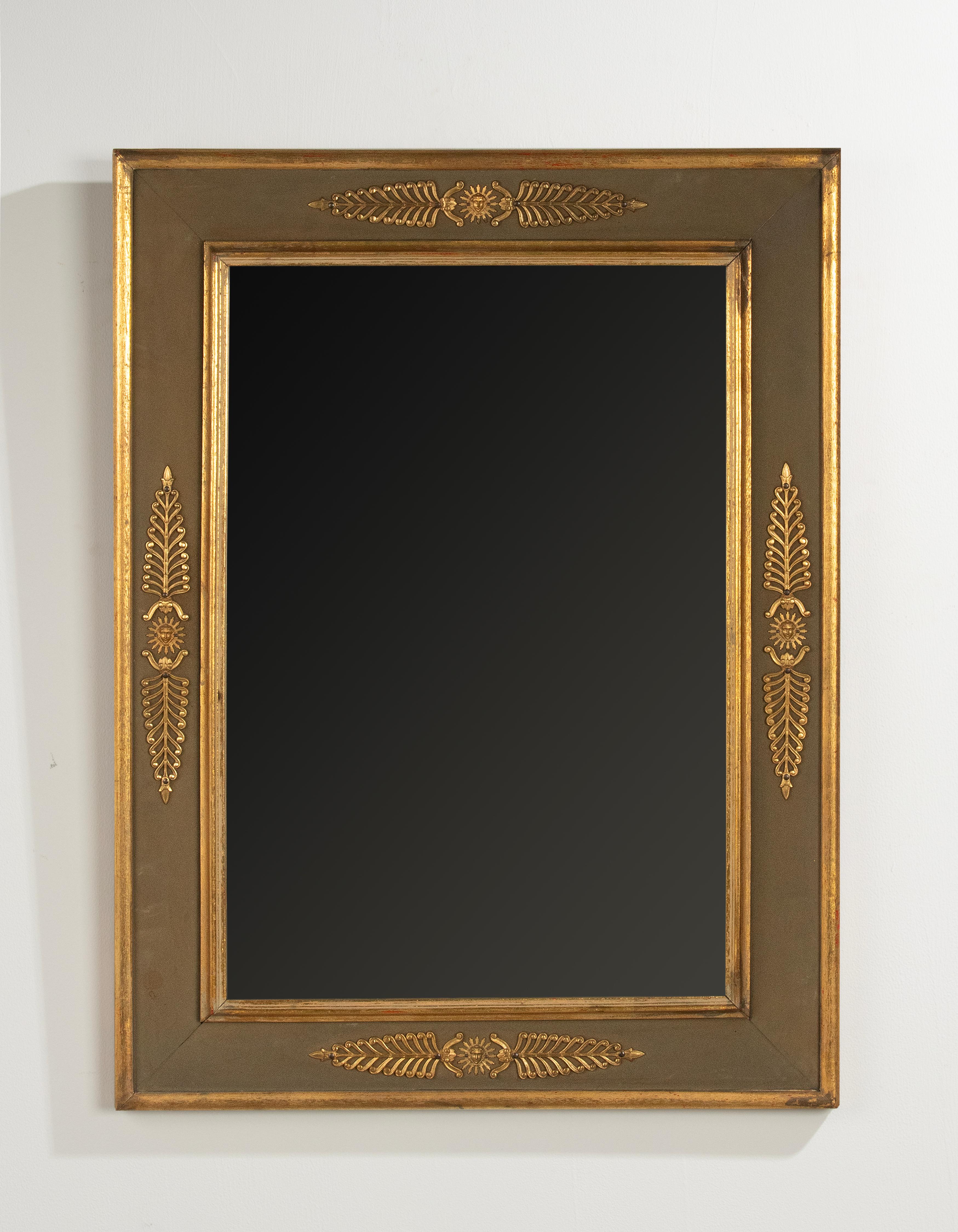An elegant small mirror, made in the French Empire style. The base os made of pine.  The passe-partout is made of green colored canvas. Decorated on each side with ormolu bronze ornaments.
The mirror is in good condition. There are a few shallow