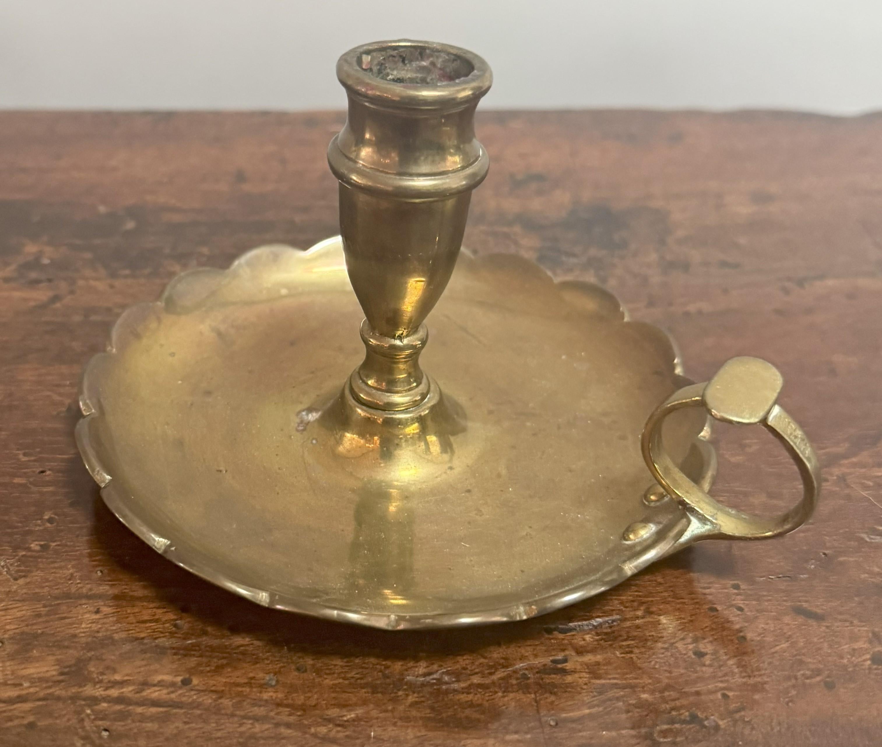 Un elegante bastone da camera in ottone della fine del XIX secolo, splendidamente realizzato con una leccarda smerlata, un portacandela svasato e un manico ad anello graziosamente arcuato. Le sue proporzioni raffinate e i dettagli sobri riflettono