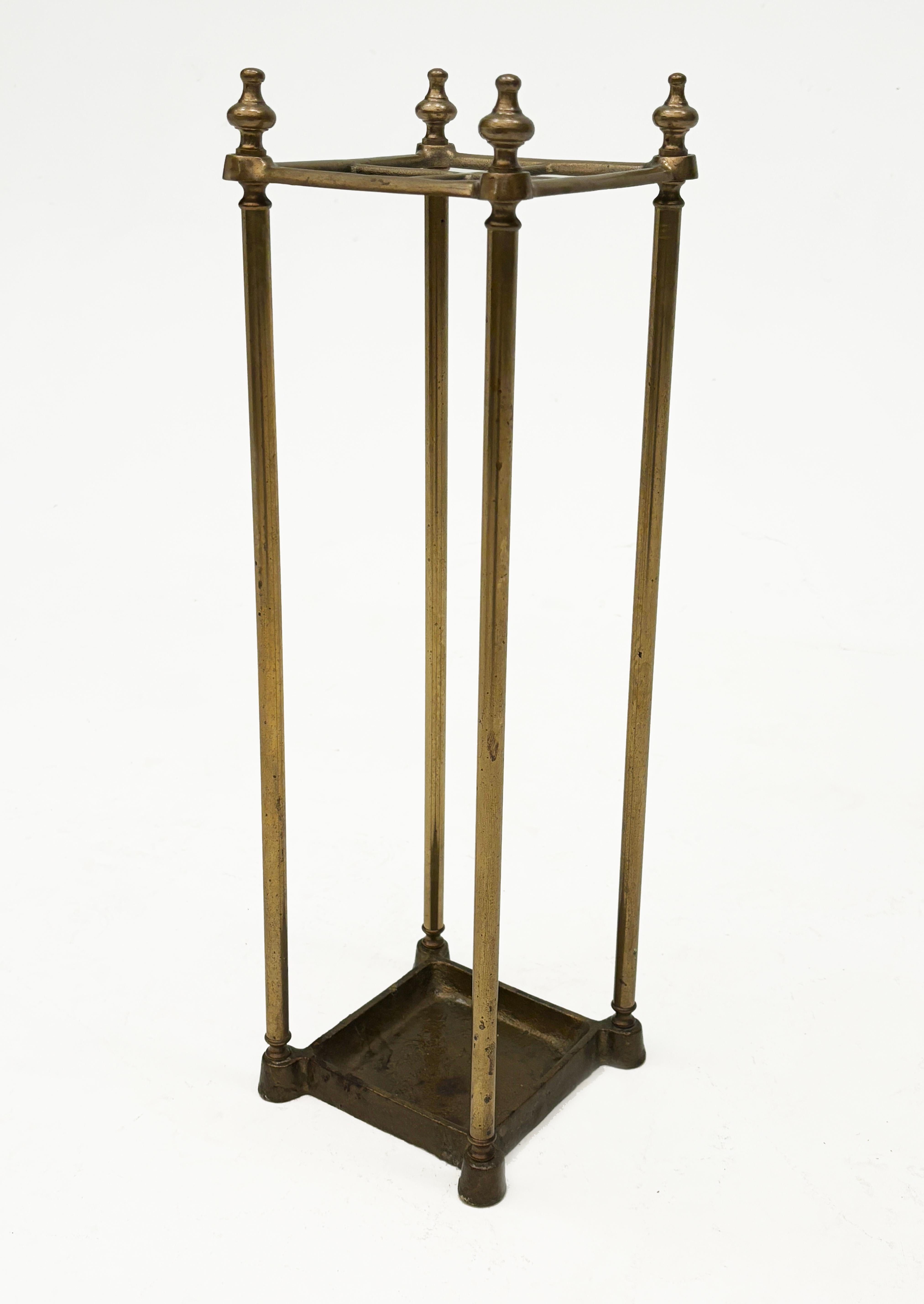 This elegant English brass umbrella stand, while amazingly functional having four compartments for umbrellas or canes and a bottom drip plate to catch water and protect flooring or floor coverings, adds a touch of elegance to any entryway. The four