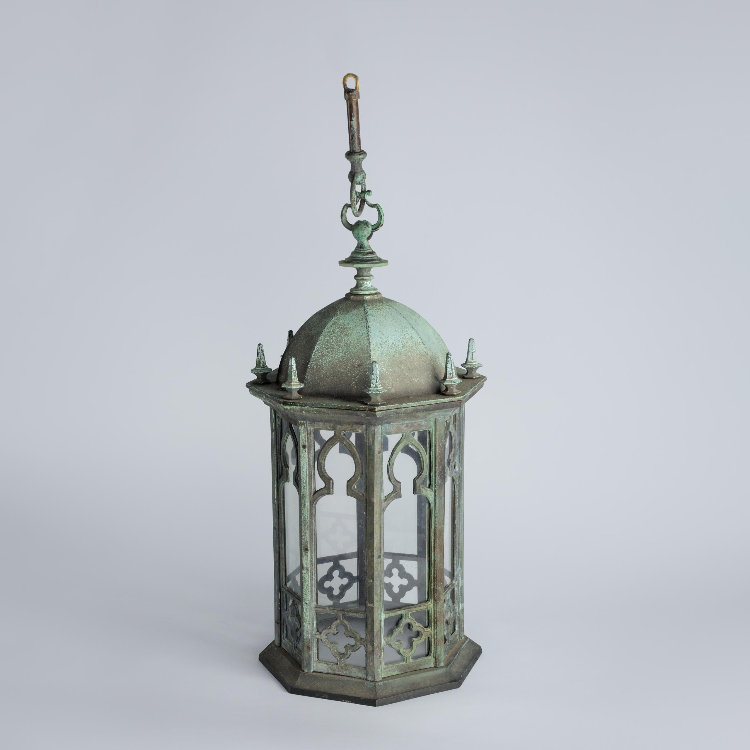 Late 19th Century bronze Gothic hall lantern with natural verdigris patination is a striking example of craftsmanship and timeless design. Intricate tracery, pointed arches and ornate detailing reflect the Gothic Revival Style. Crafted from solid