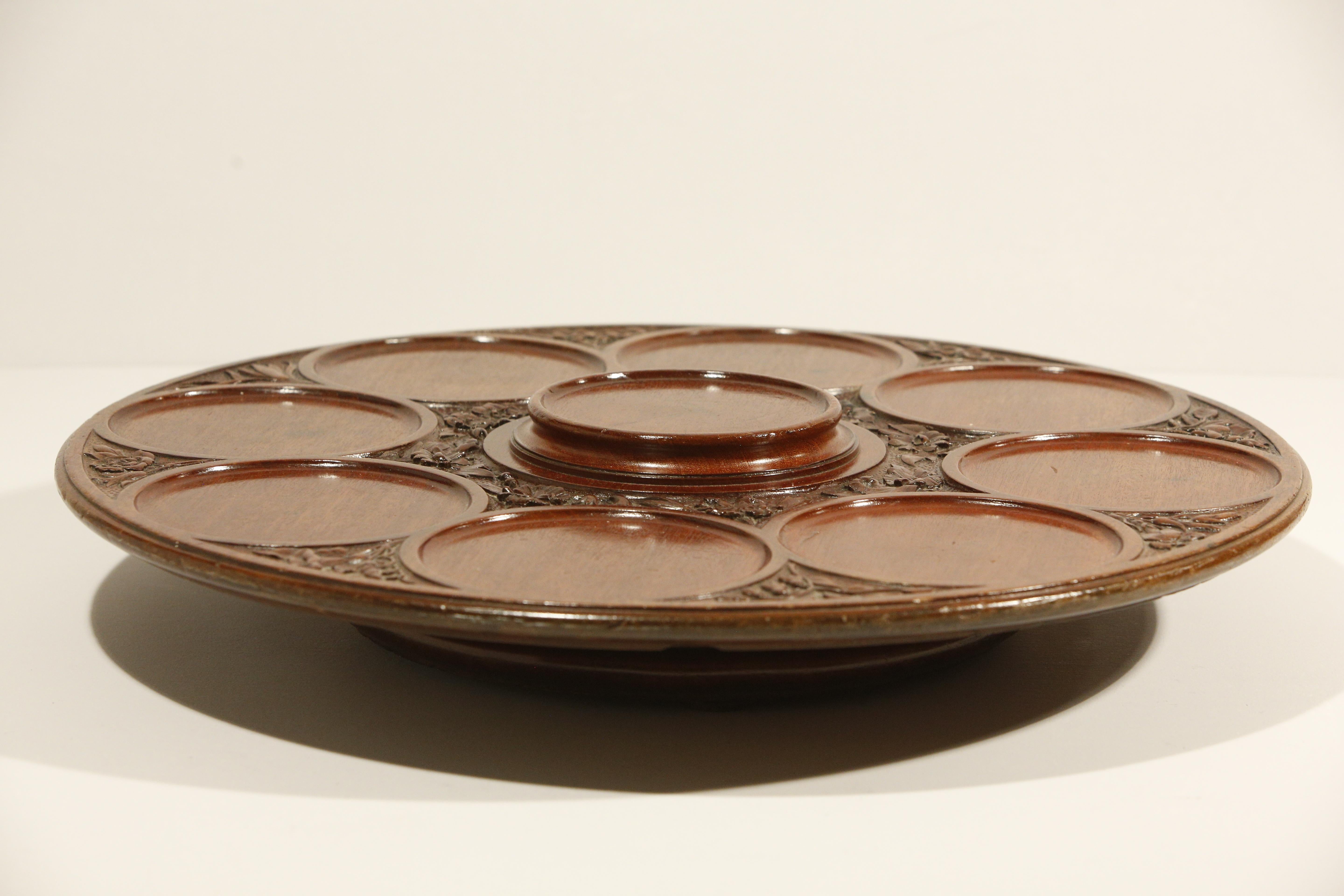 Late 19th Century English Carved Lazy -Susan 

A large and intricately carved lazy-susan, the foliate motifs dividing the 8 sections for serving dishes with a raised centre section on 4 feet. 
 