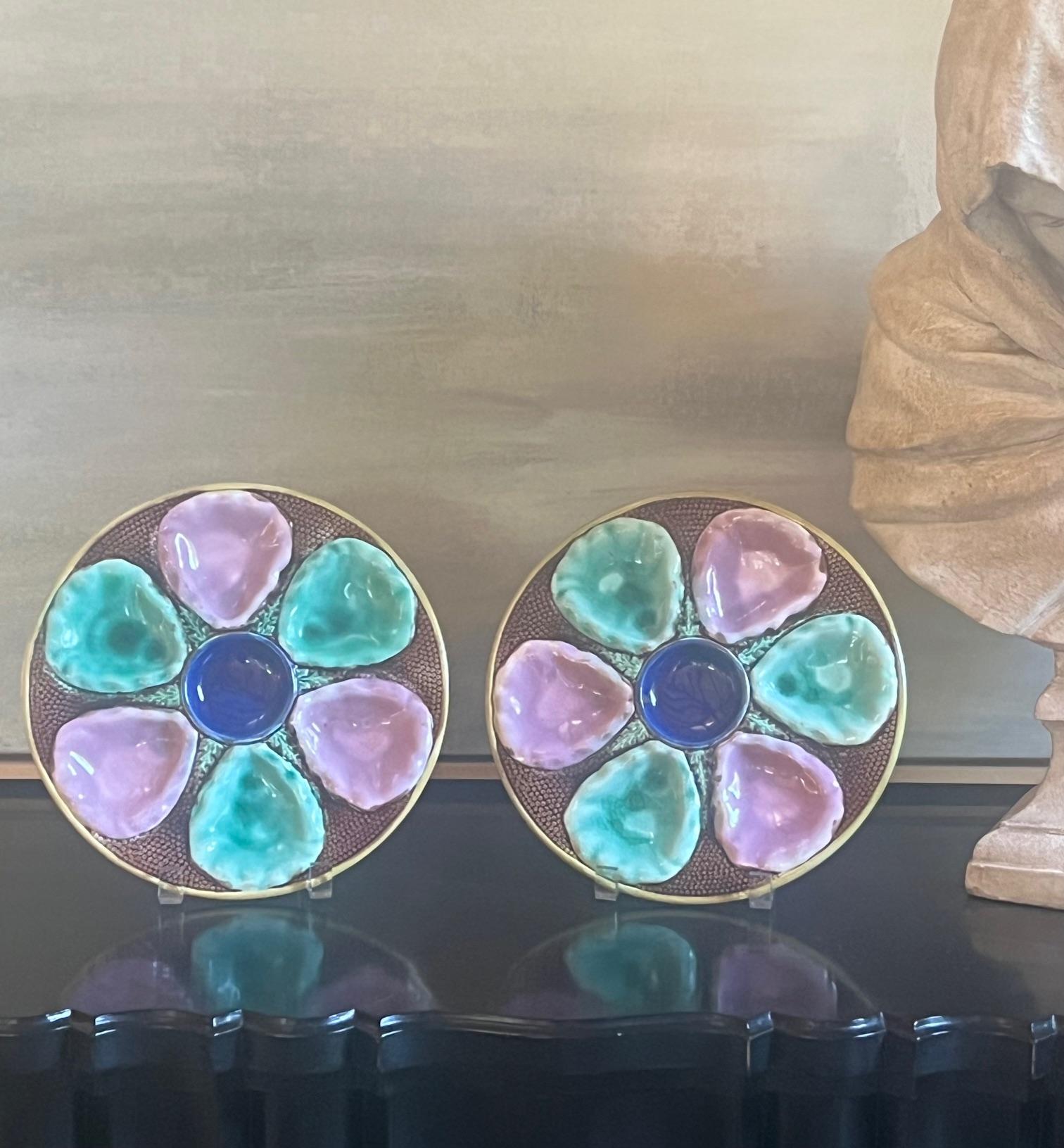 Late 19th century English majolica oyster plate with pink and turquoise wells, a blue center for lemon wedges and a brown background. 
