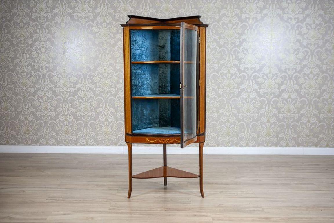 Late-19th Century English Corner Cabinet in Brown

An inlaid piece of furniture with a light construction and a curved front, featuring glass doors and supported by three curved legs, reinforced with a shelf at the bottom. The top of the furniture