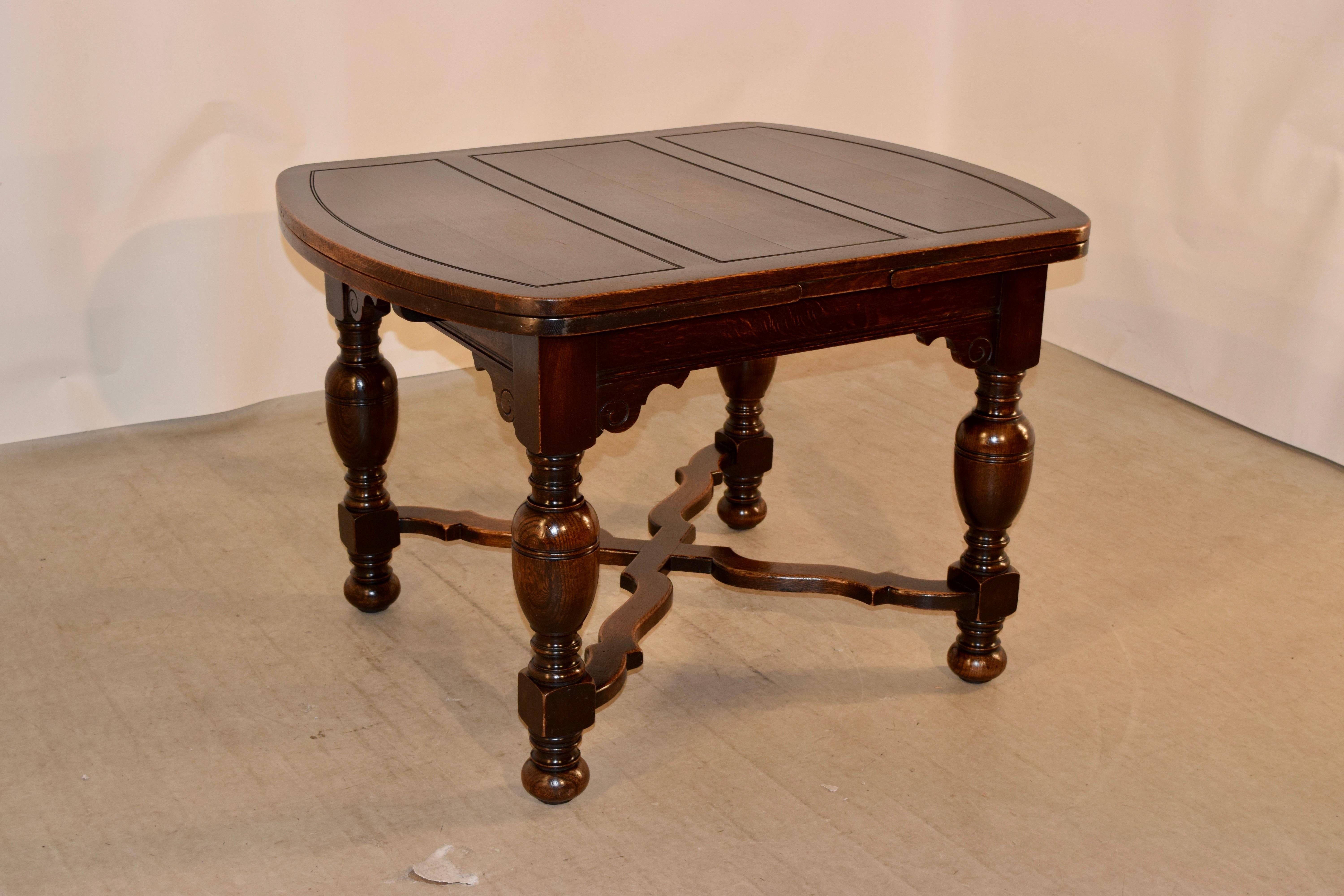 Late 19th century oak draw leaf table from England. The top has three panels with shaped ends, and has two paneled leaves that pull out and are shaped to match. The apron is routed along the edge and is embellished with scrolled brackets. The legs