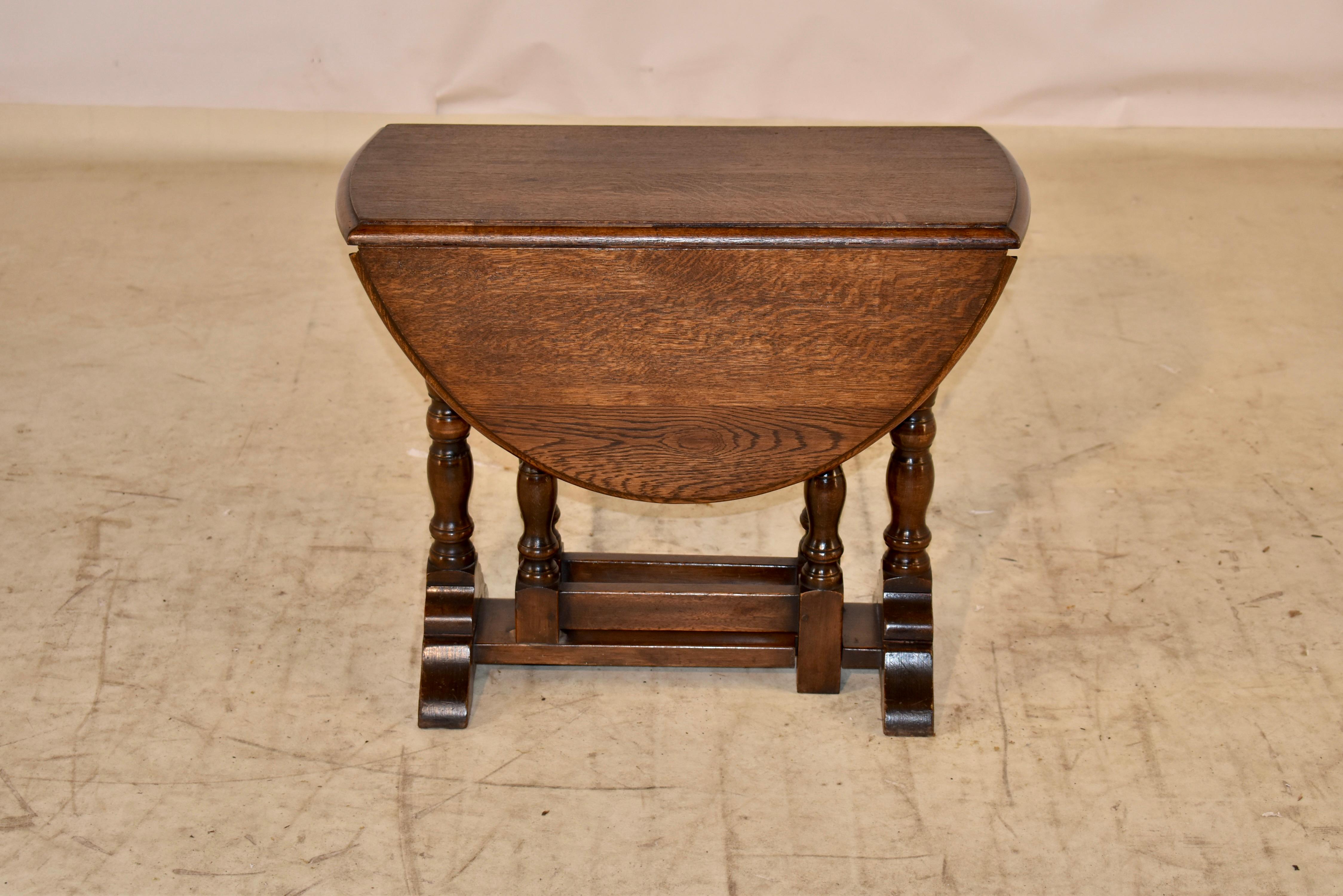 Late 19th century small oak side table with drop leaves from England.  The top has a beveled edge, and has lovely graining and patina.  When the leaves are extended, the top open measures 30 w x 24 d.  the base is a simple trestle style, with hand
