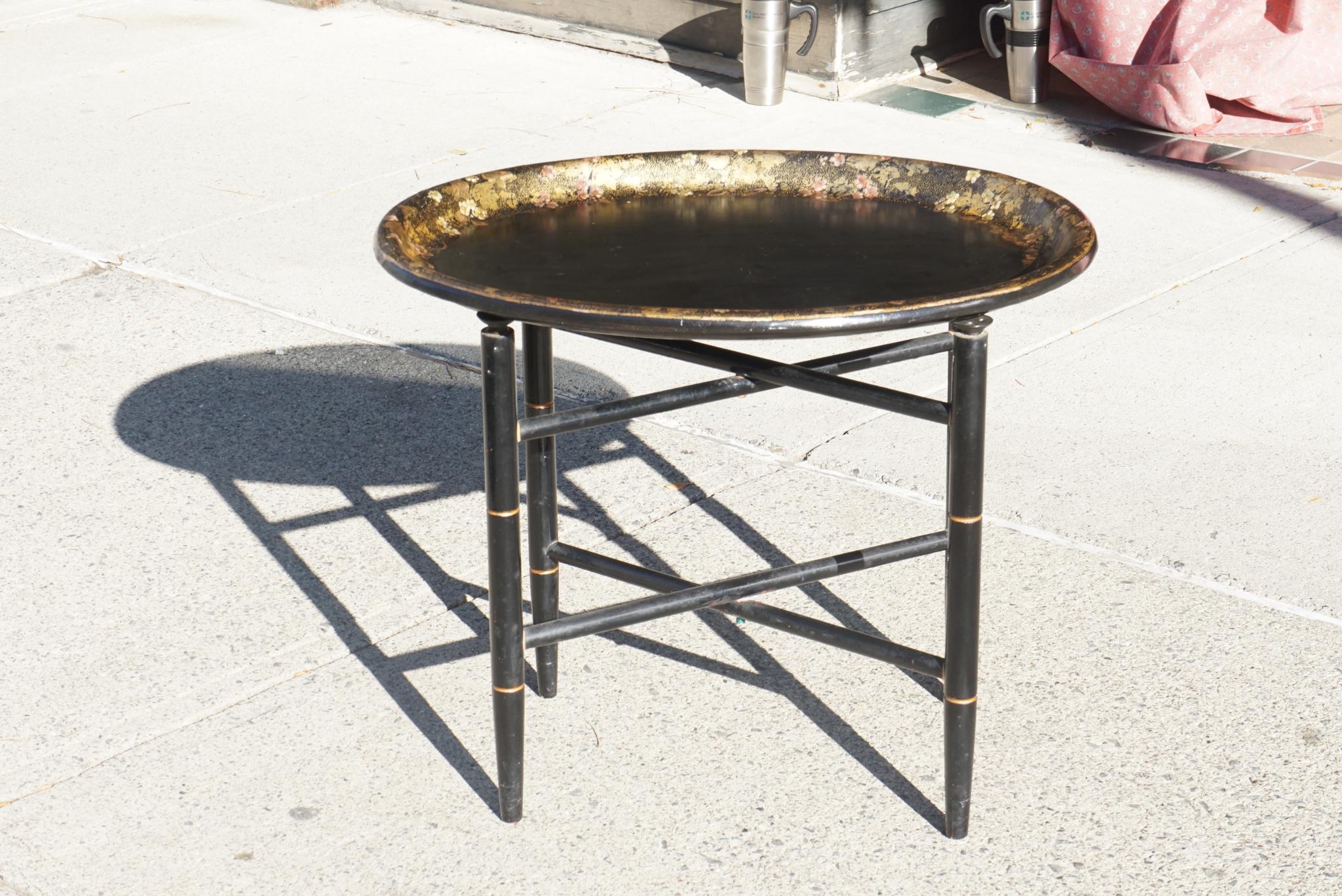 This very nice old papier-mache tray produced approx 1885 comes from England while the stand is a modern addition creating a useful and attractive small coffee table. The base is made to imitate bamboo and is lacquered black with gilded lines