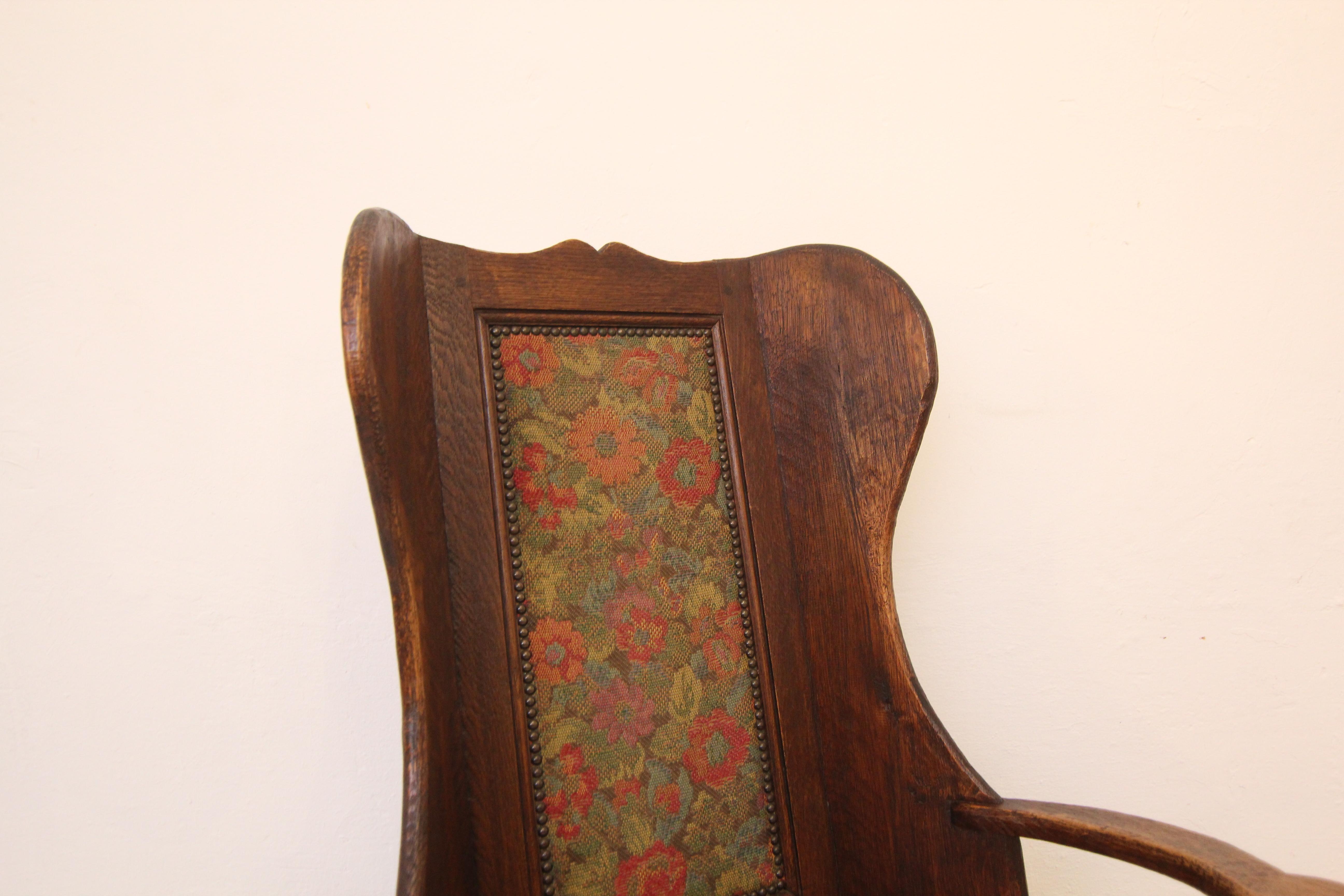 A English provincial lambing chair. Probably from the late 19th century made in the style of the traditional lambing chairs from the 18th century.

A wing chair on runners made of oak planks with slightly concave armrests and a high backrest framing