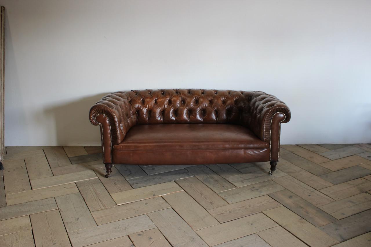 A late 19th century English Chesterfield sofa in tan leather, deep buttoned with turned legs and original castors.
Measurements: 39cm high (floor to seat)
England, circa 1890-1900.
 