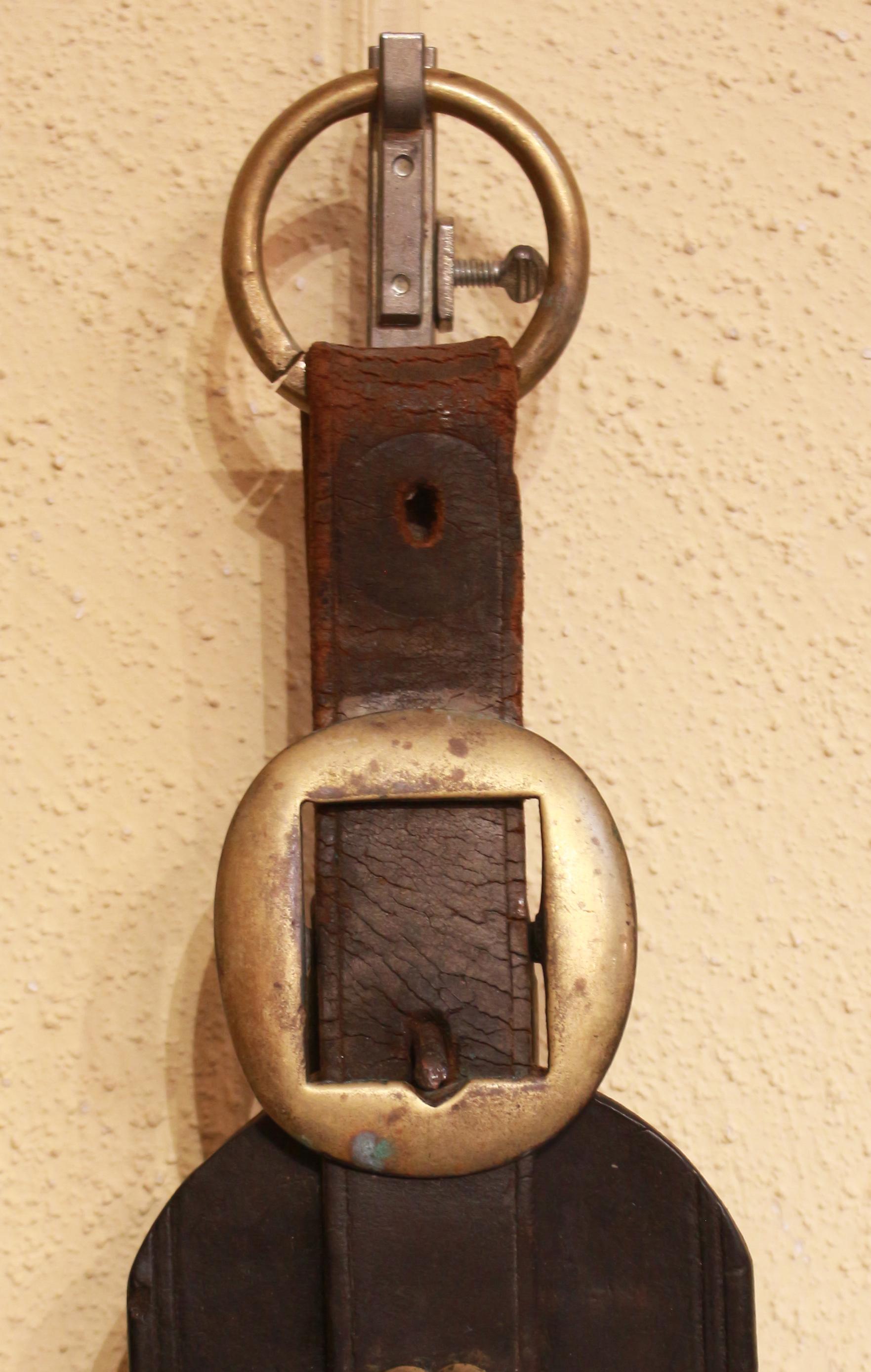 Late 19th century English long leather horse strap. Straight leather strap with rounded top adorned with heart & oval boss above the horse brasses of a horse bust in horseshoe, the symbol of 