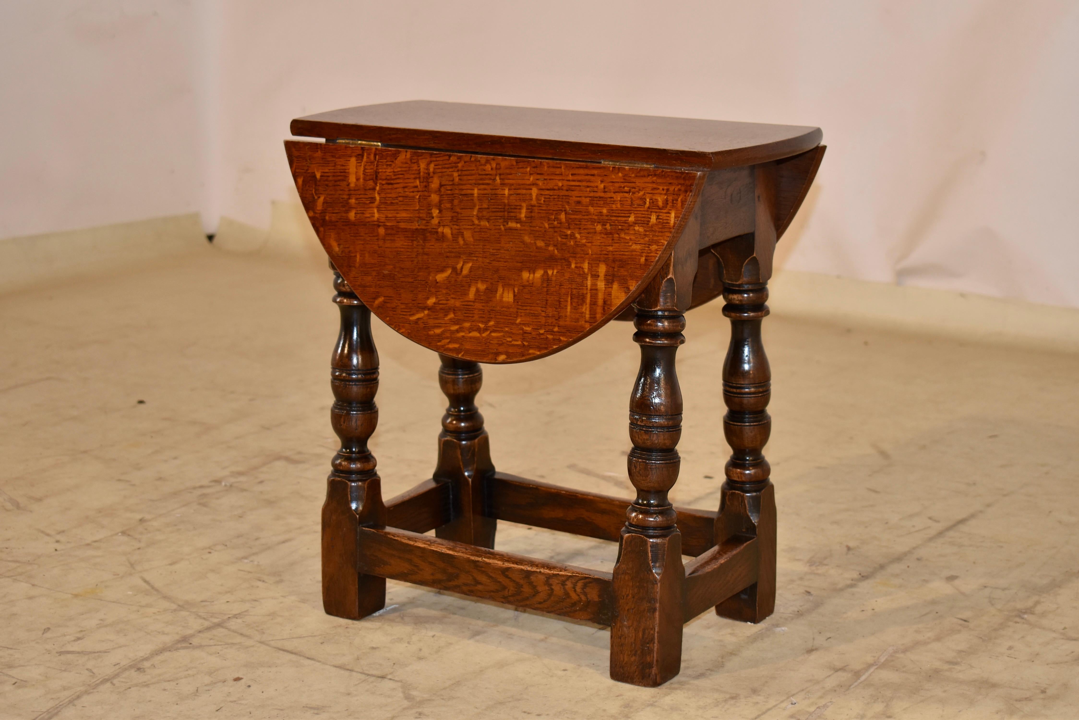 Petite table d'appoint en chêne anglais de la fin du 19e siècle, avec feuilles tombantes.  Le plateau est en chêne joliment grainé et se prolonge par un tablier simple et deux supports extensibles pour les feuilles.  Les pieds sont tournés à la main
