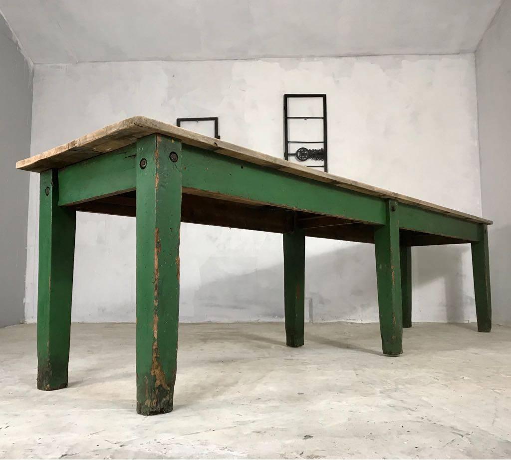 A very long English pine table, sourced from a Lincolnshire stately home, with old green paint and beautiful pale elm top. The top has an area of corrosion, as shown in the picture, however this does not detract from it's look or practicality.