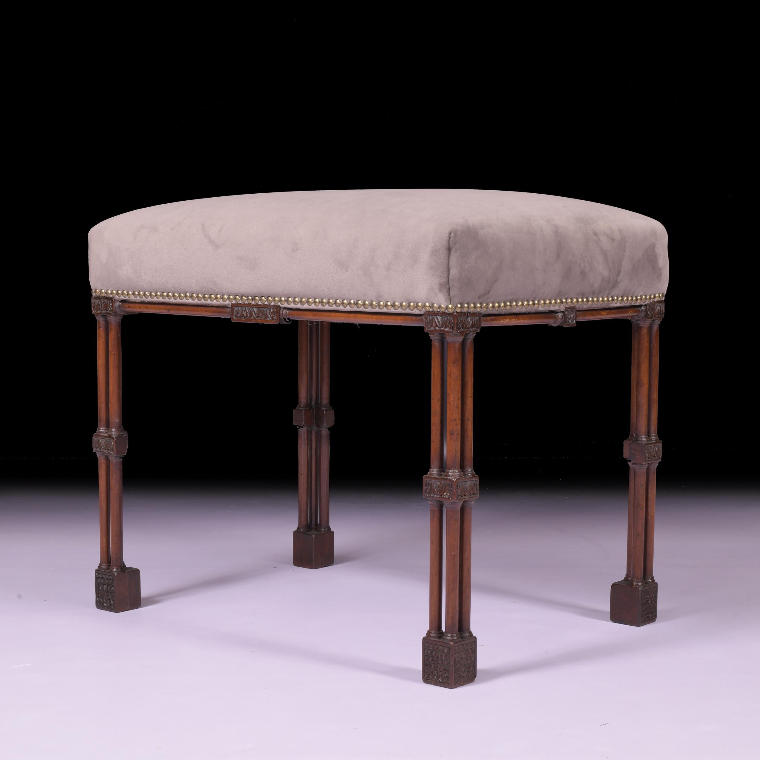 Taburete rectangular con marco de caoba inglesa de principios del siglo XX, con la parte superior acolchada y cubierta de terciopelo gris, elevado sobre cuatro patas de columna perforadas que terminan en pies de bloque.

Alrededor de 1900

Inglés