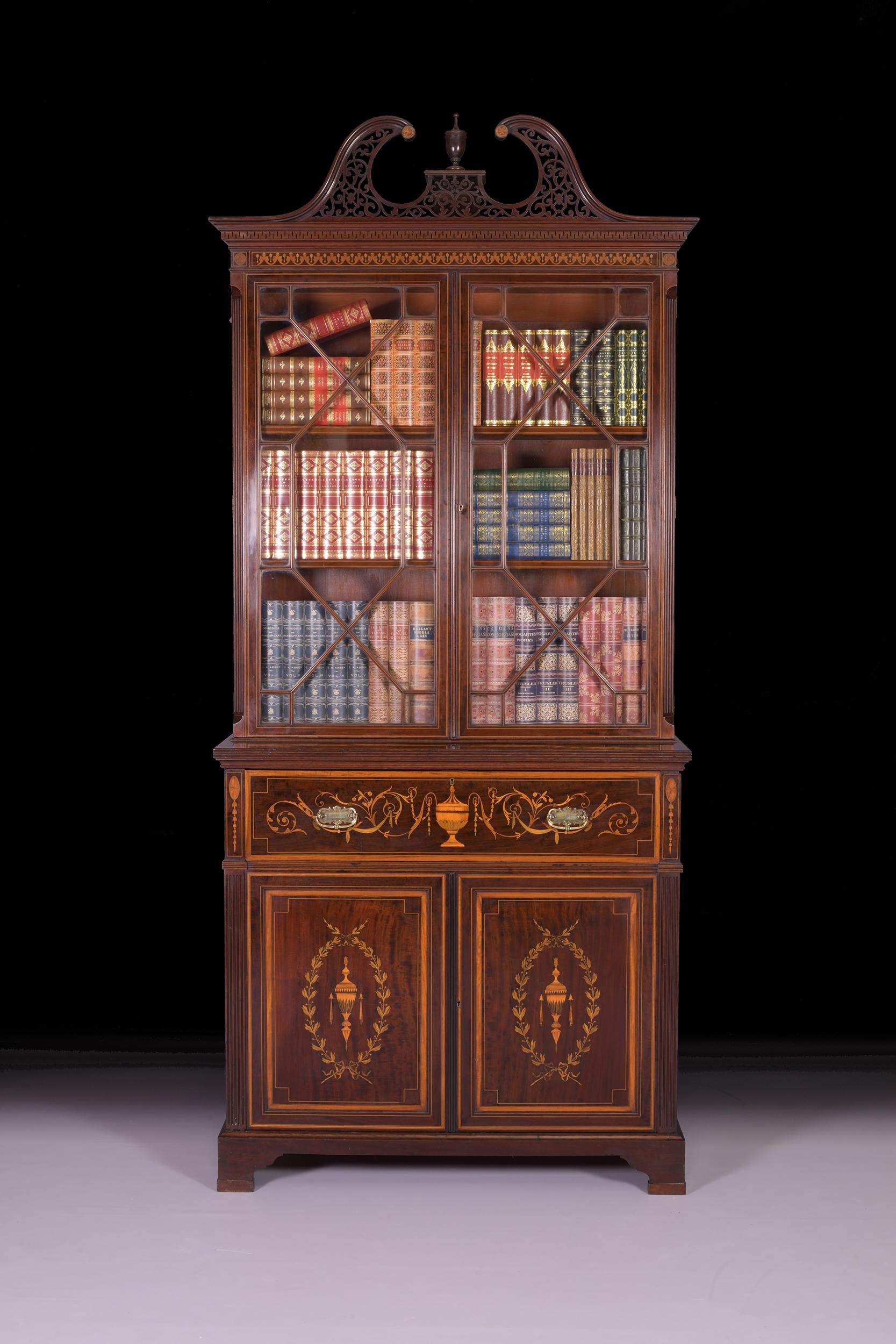 An exceptional late 19th century secretaire bookcase by Edwards & Roberts, the upper section with a pierced fretwork swan neck pediment with Greek key moulding. The twin astragal glazed doors open to reveal an adjustable shelved interior, having
