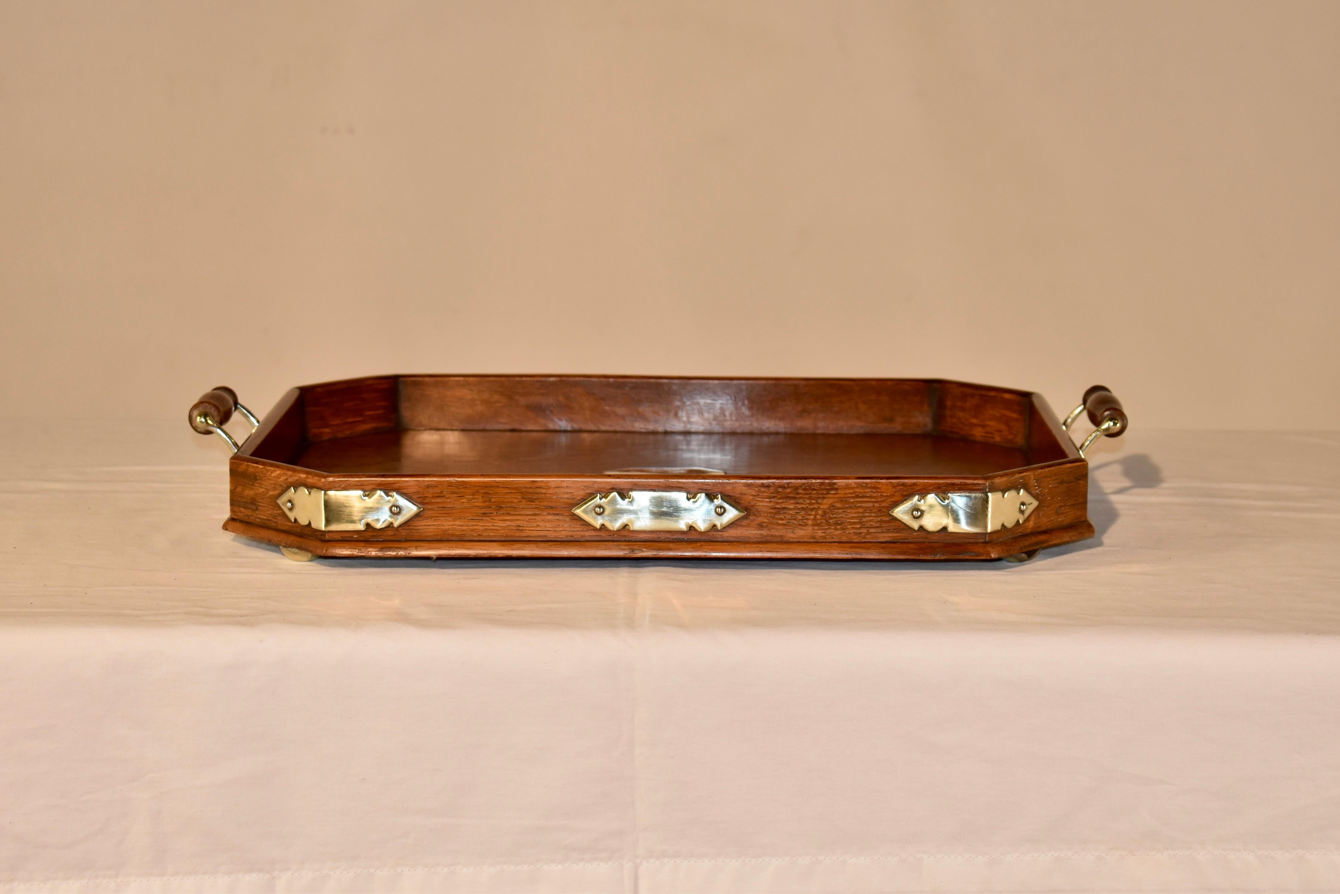 Late 19th century oak and silver plate treen tray from England.  The tray is very simple and elegant, with silver plate adornments on the corners and a central silver plate plaque.  It has lovely hand turned handles with silver plated hardware, and
