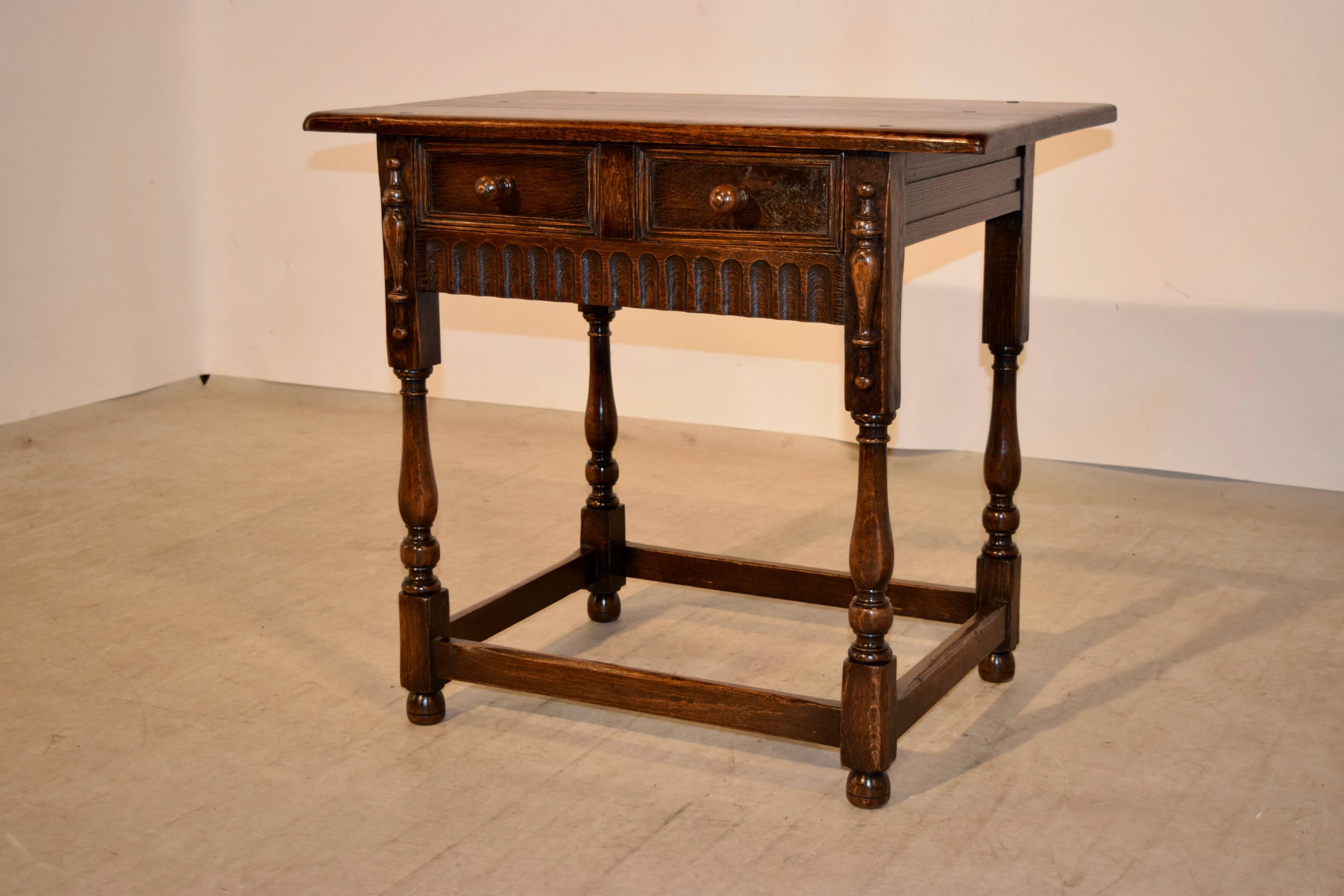 19th century English oak side table with a thick tow board top with pegged construction, following down to panelled sides and a single drawer in the front, also with raised panels on the drawer front. The drawer is flanked by applied half turnings