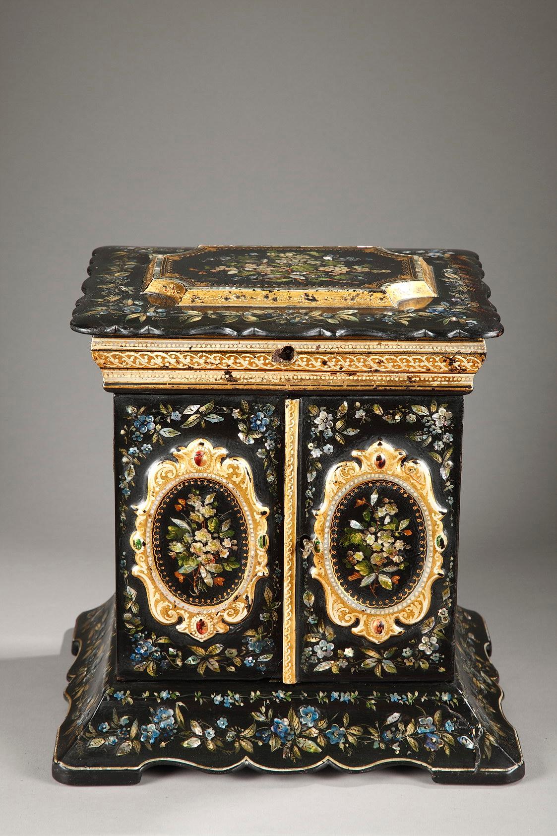 Late 19th century table casket decorated with mother-of-pearl inlay and painted flowers. Two oval medallions with bouquets of flowers and scrollwork adorn the two doors on the main face. The interior is composed of a central niche and eight drawers