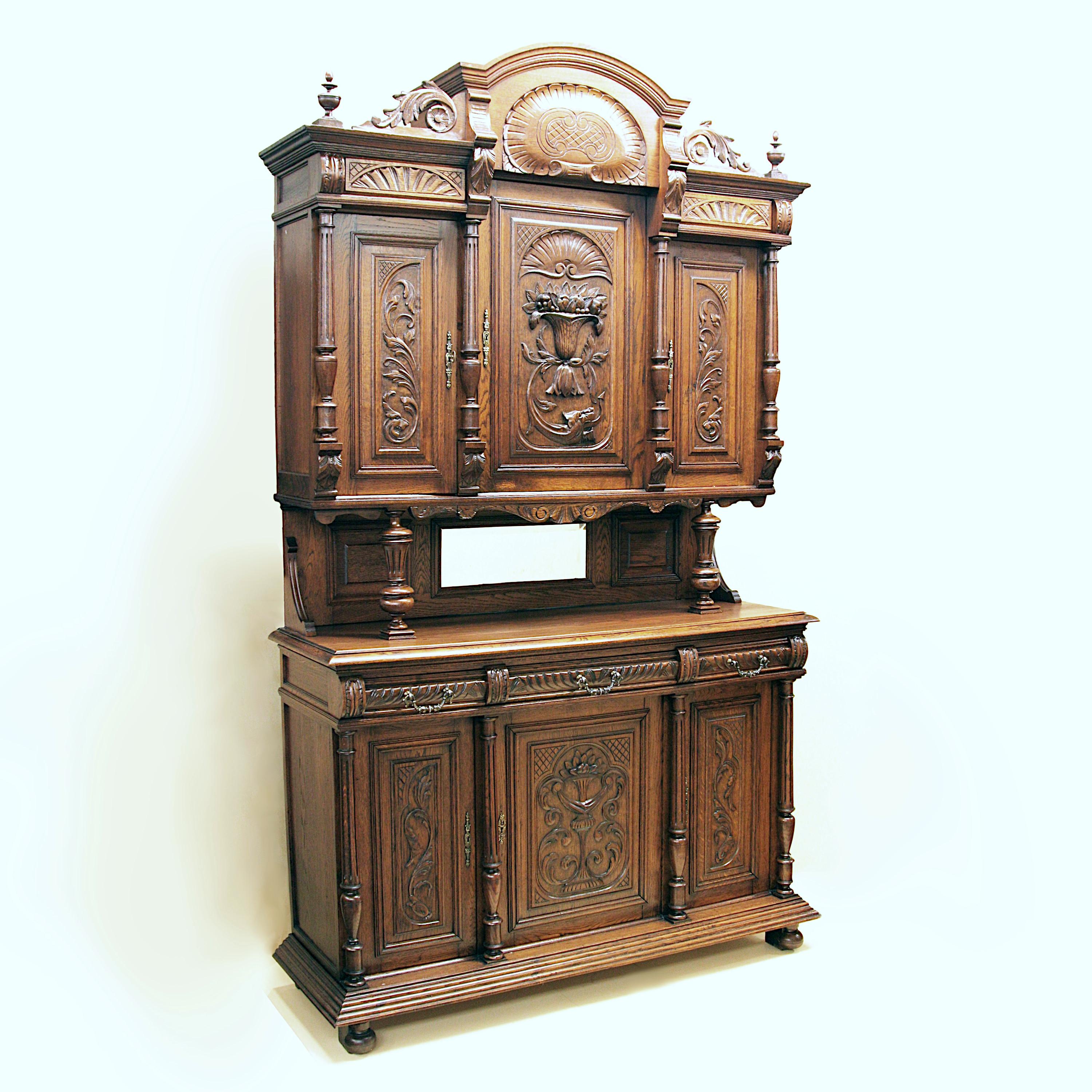 Wonderful turn-of-the-century English Victorian Break-Front Cabinet

Features include:

- Solid Oak construction
- High-relief carving throughout
- (3) Drawers
- (6) Doors
- (3) Interior shelves
- Solid Brass Hardware
- Mirror

This
