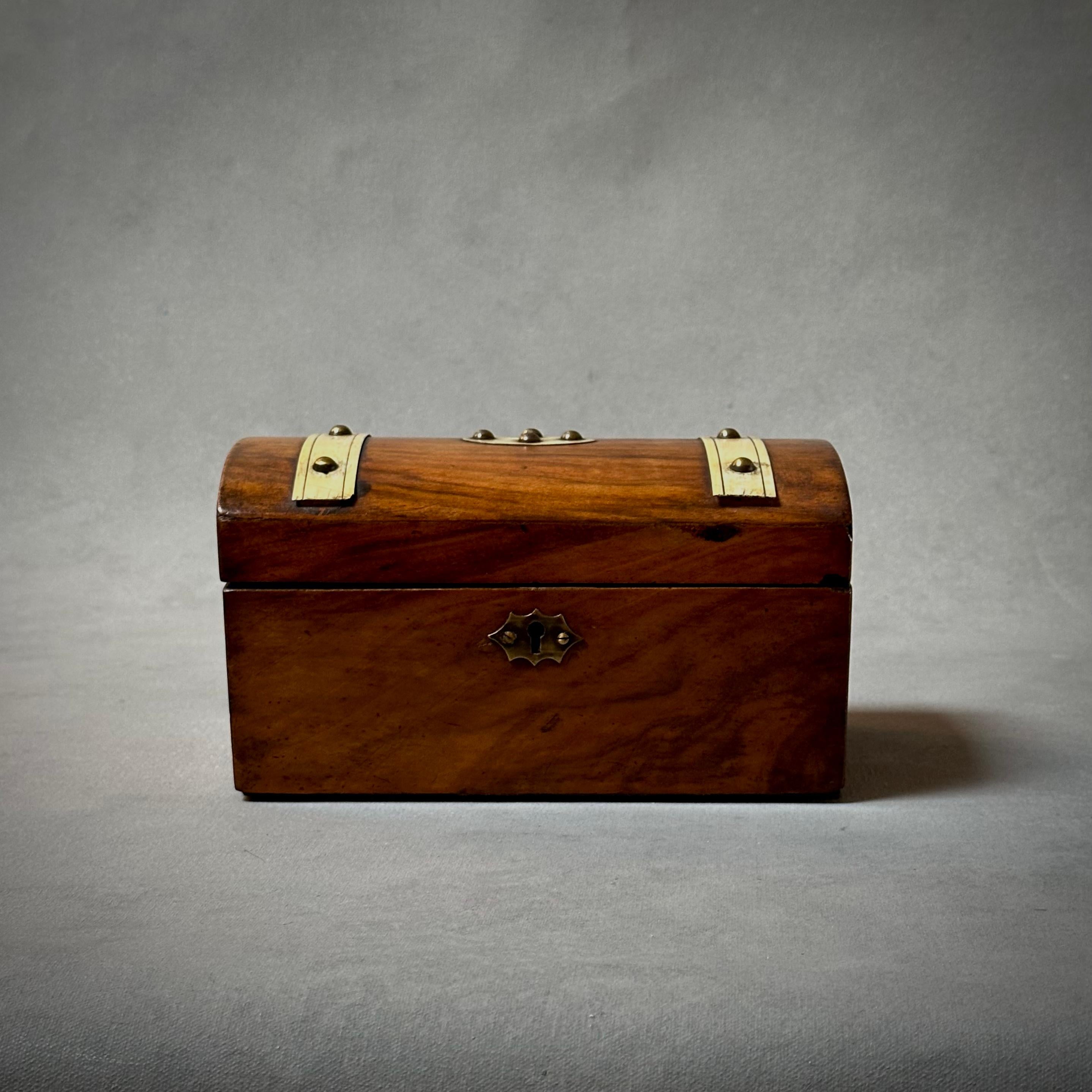Late 19th century English walnut tea caddy box with studded ivory leather decorative banding. Traditional with utilitarian sensibility, the piece's unique detailing evoke a steam trunk. Great for adding an element of textural interest to any