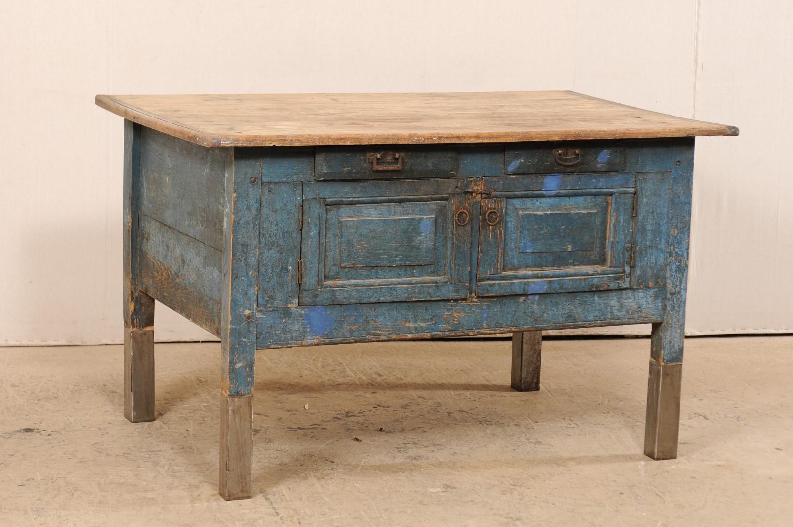 A European workbench or table from the late 19th century with contemporary additions. This antique farmhouse style table from Europe features a rectangular-shaped overhanging top, above a deeply set apron which houses two small drawers over a pair