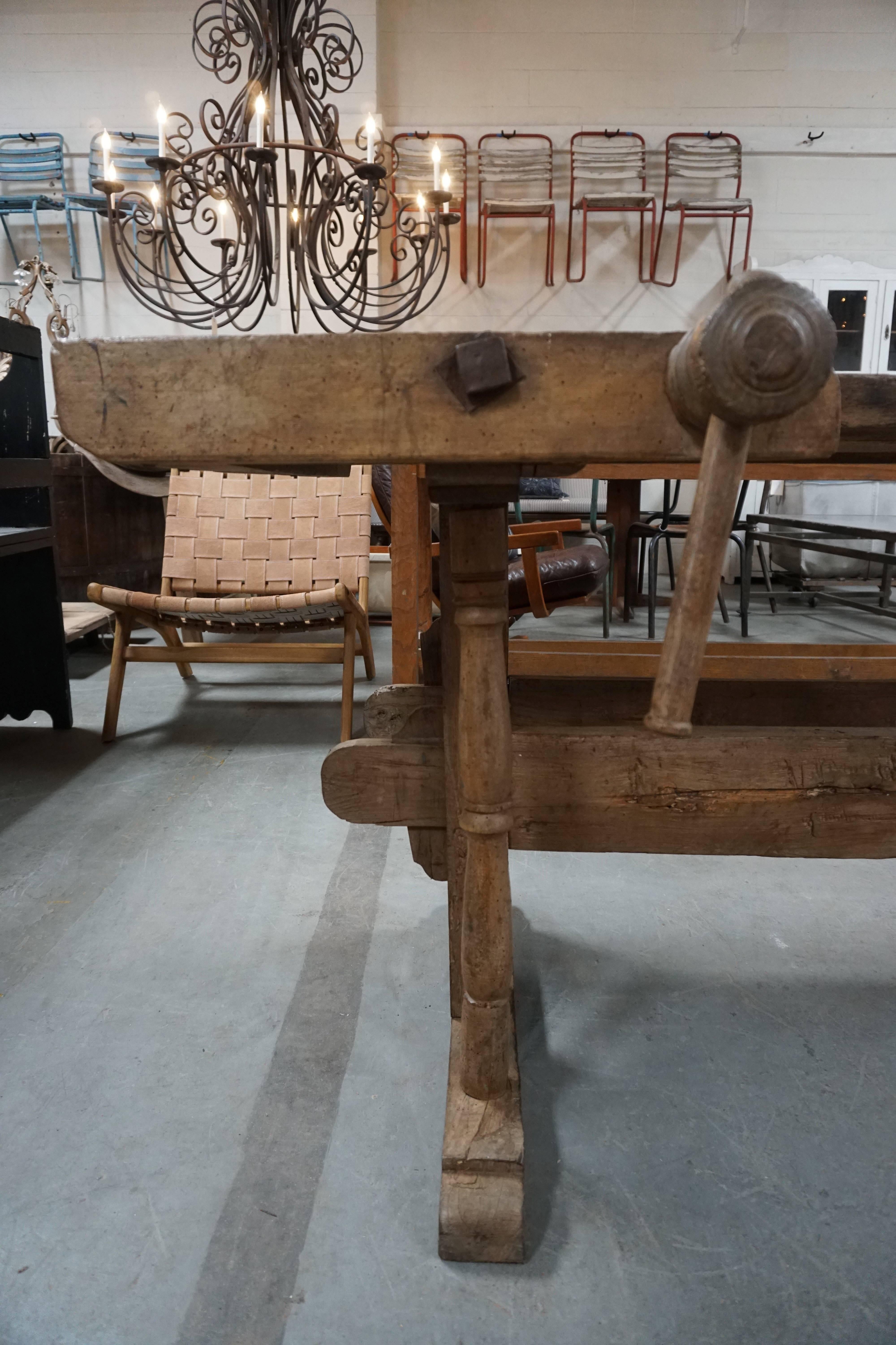 Super unique late 19th century French work table. Features hand-carved built-in wood vices and clamps. Solid wood top sits upon trestle base. Truly a one-of-a-kind piece!